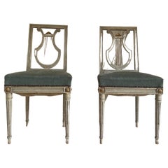 Pair of painted Louis XVI style chairs with blue velvet seat