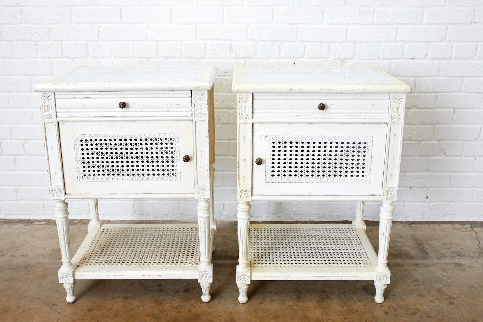 French Louis XVI style or Swedish Gustavian taste pair of painted nightstands. Featuring a white marble top and two-tier design by Rachel Ashwell. Known for her country French and beach cottage style these pieces are from her couture line. Fronted