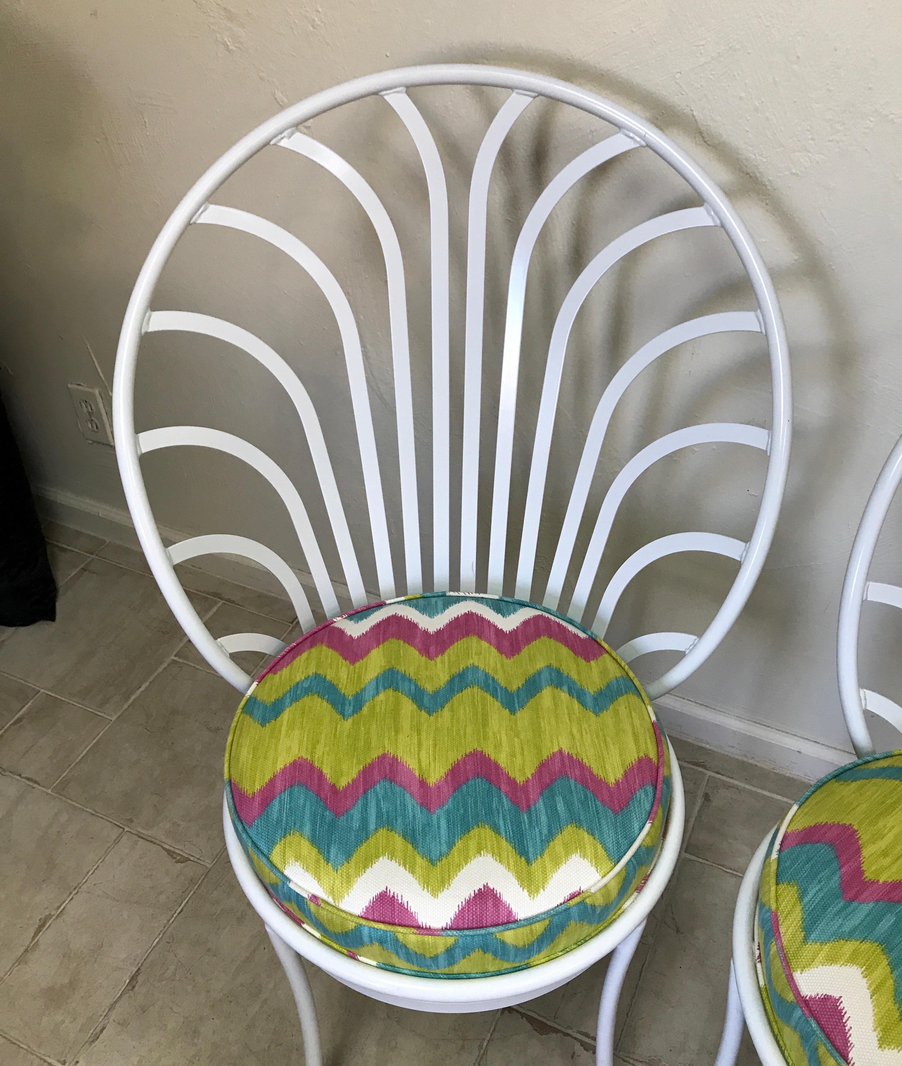 Pair of white lacquered metal peacock chairs with newly upholstered ikat pattern fabric.
