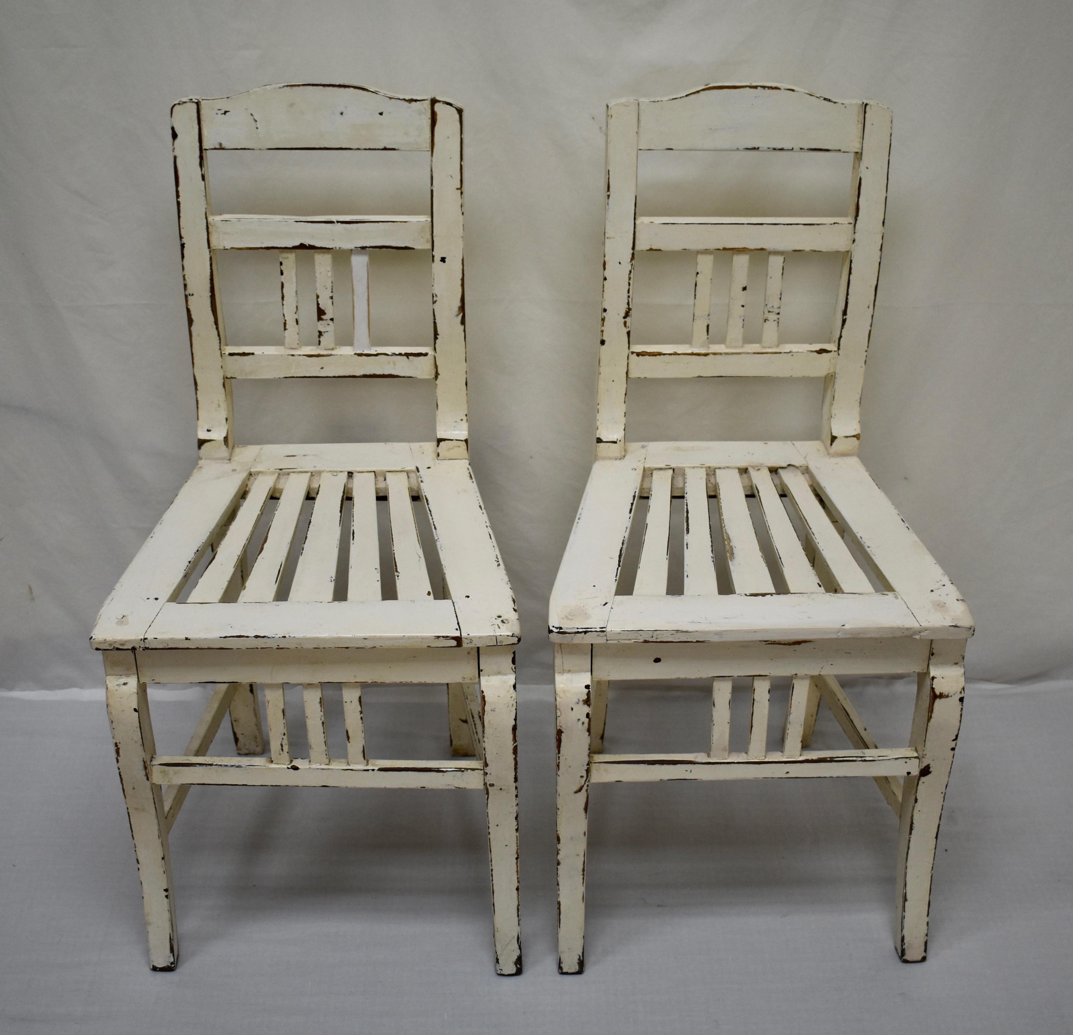 These are an interesting variant on a common style of central European side chair. The back rail has a slightly curved top and the two straight rails beneath frame three vertical slats. The shape of the Queen Anne style front legs, also with a