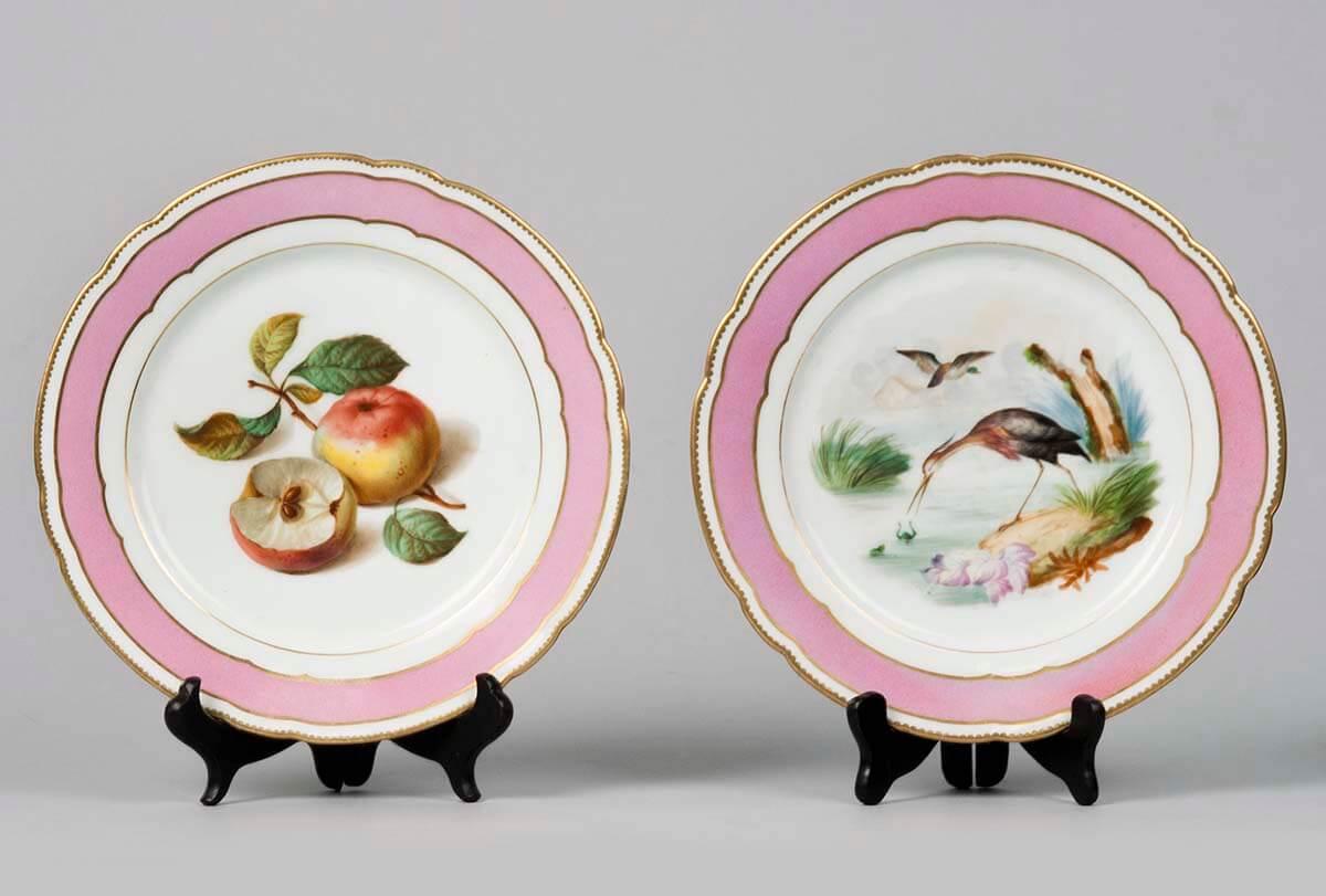A couple of decorative cupboard plates with a striking pink border.
These porcelain plates are made in Paris, on the back they are marked 'Bourgeois, Rue de Saint Honoré 376.' In the 19th century there were many small studios in Paris where
