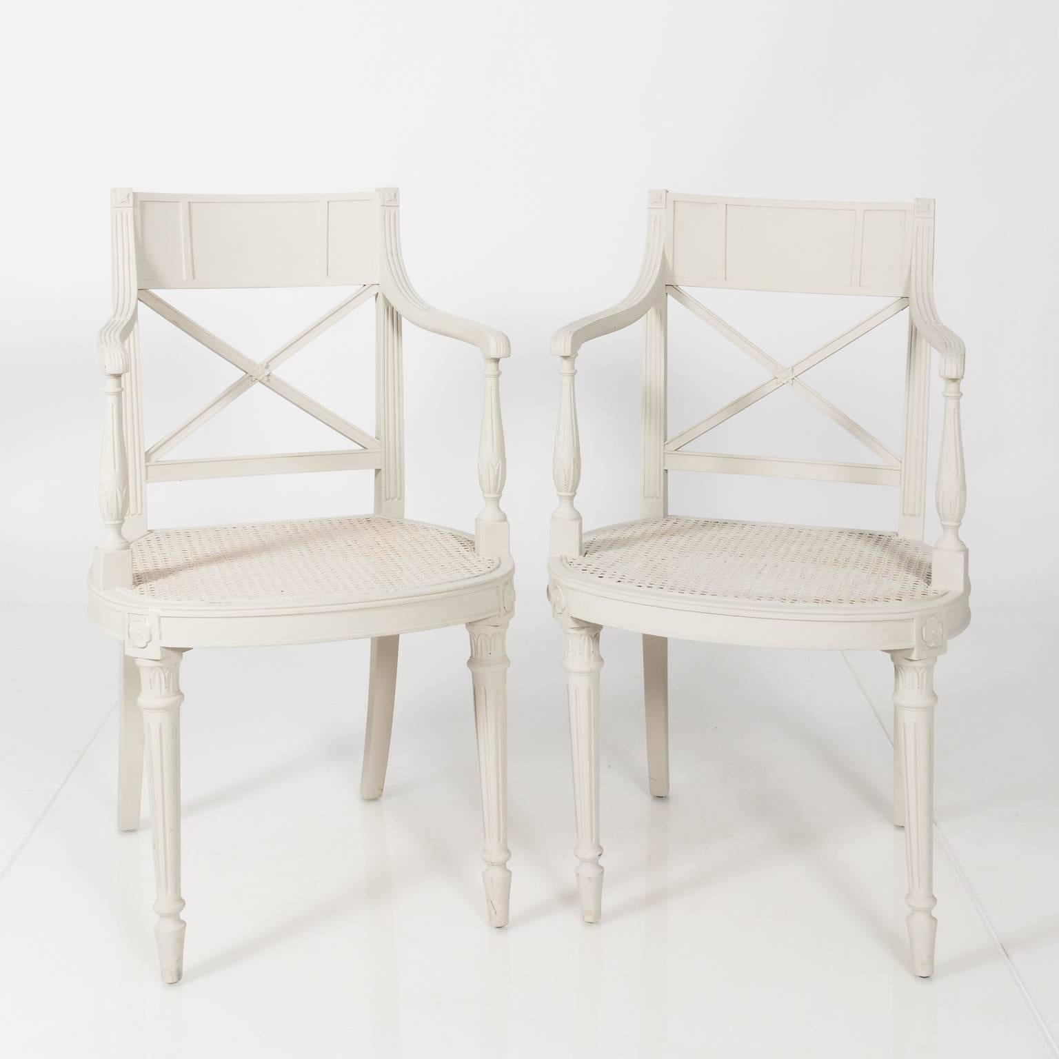 Pair of Regency style white painted chairs with caned seating and a latticework back, circa early 20th century.
 