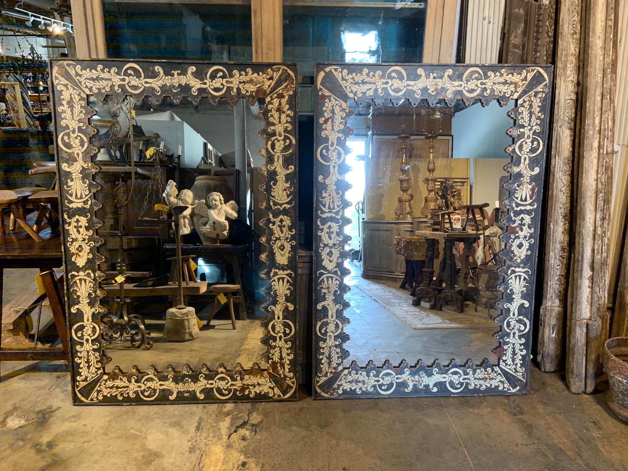 A terrific pair of Spanish mirrors constructed from painted reclaimed metal. The glass has been lightly crazed.