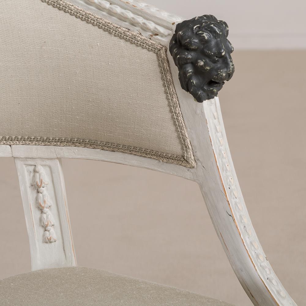 Coppia di poltrone svedesi del primo Impero dipinte con maschere di leoni verde scuro. Le cornici sono intagliate con flora e con la vernice originale grigia e rovinata, risalente al 1800 circa.
  