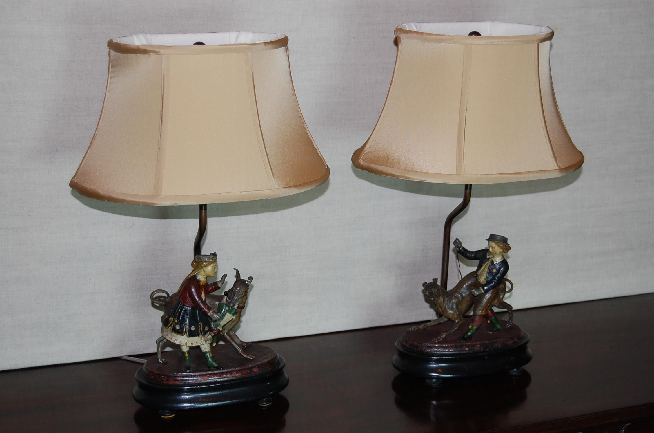 Pair of exquisite hand painted tin figures of children playing with their dogs in original finish on the original oval wooden bases, circa 1830. Pair of custom made silk shades and just rewired. Possibly German or Russian in origin.