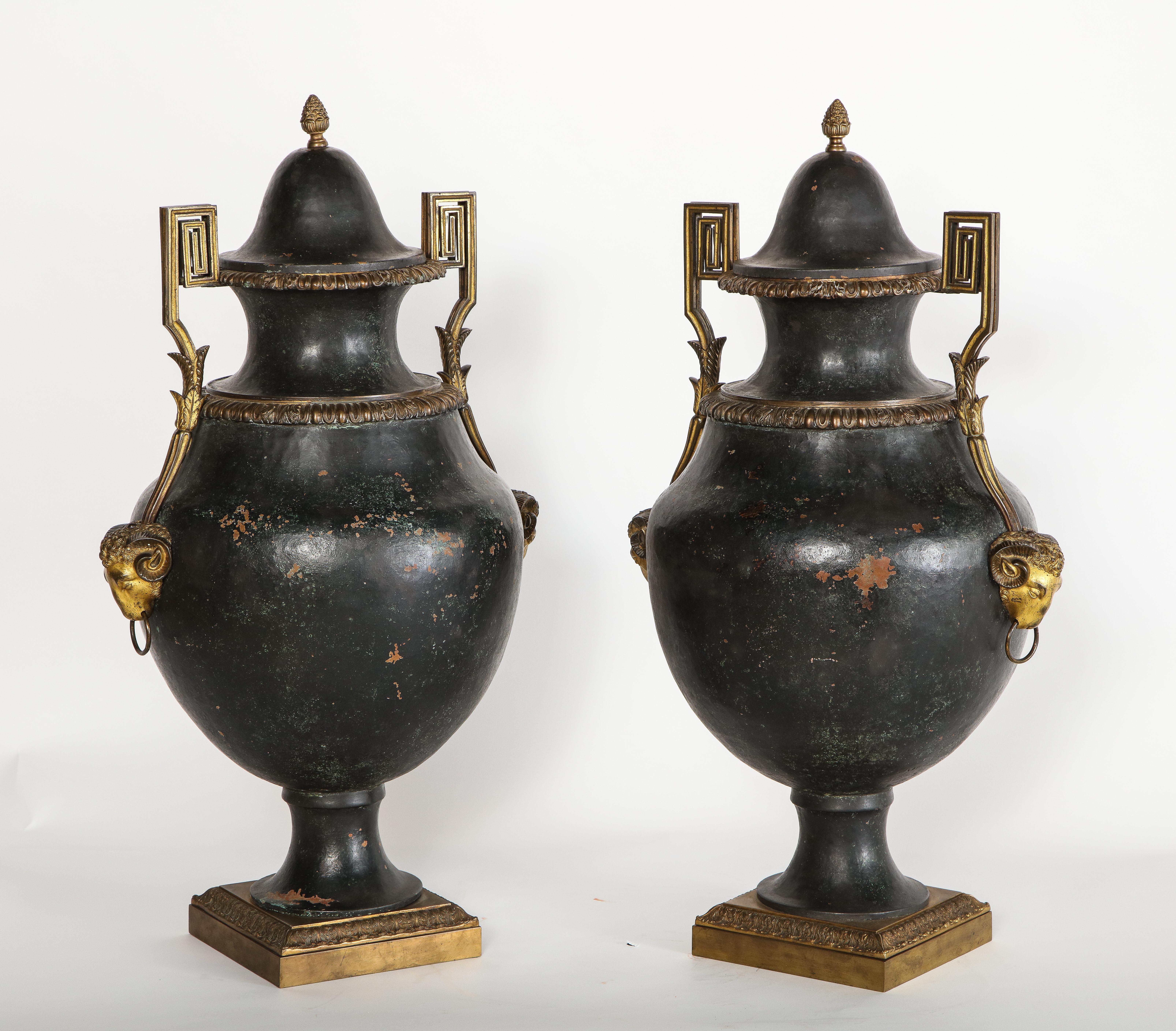 A fabulous and Palace size pair of French/North European painted tole and dore bronze mounted neoclassical covered vases. This beautiful pair of original covered vases are exquisitely made with a fabulous black patinated tole body each with two