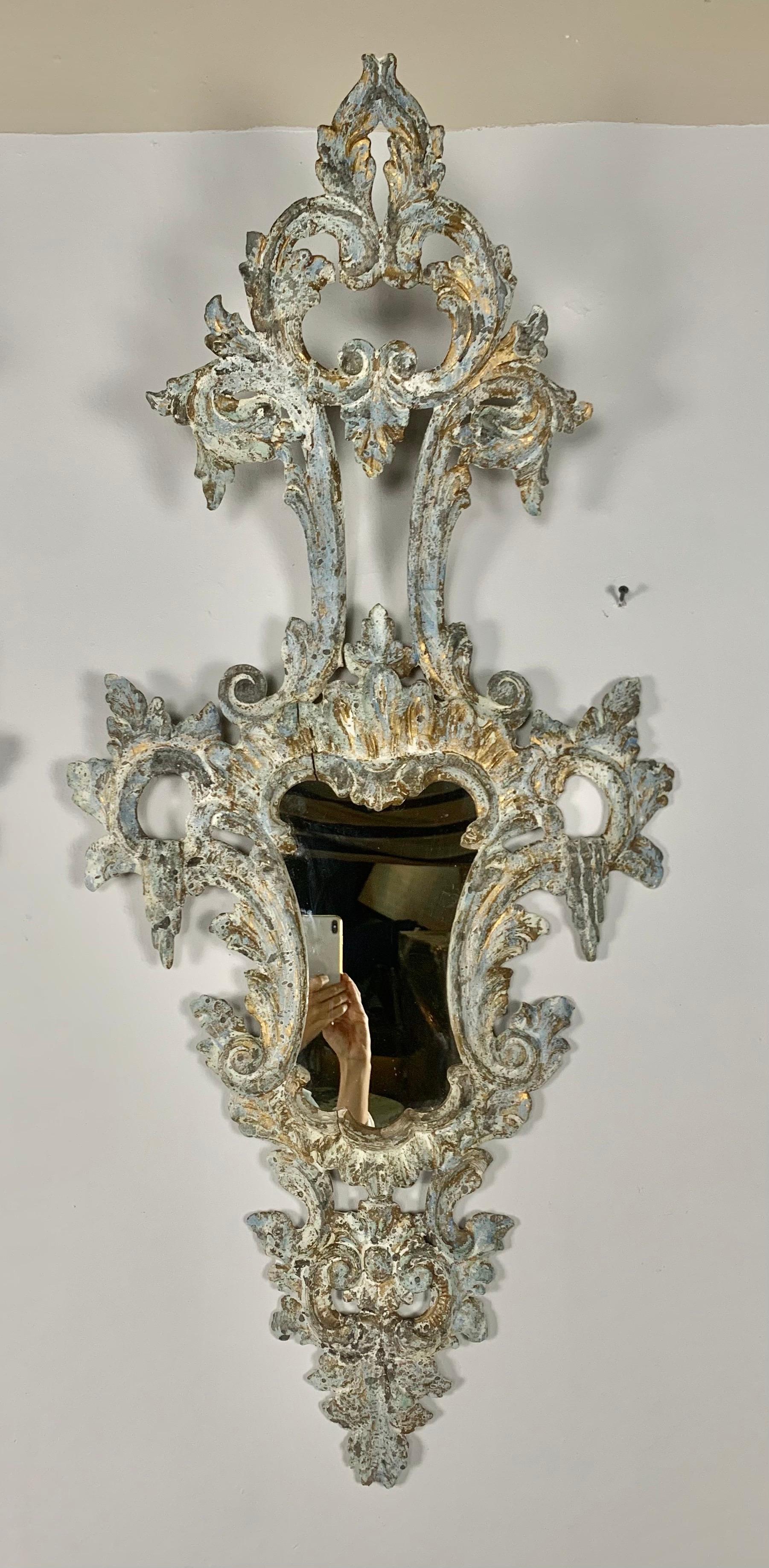 Pair of carved Italian Venetian mirrors. The mirrors are painted with highlights of gold leaf throughout. They are a soft blueish gray with antique white and gold throughout.