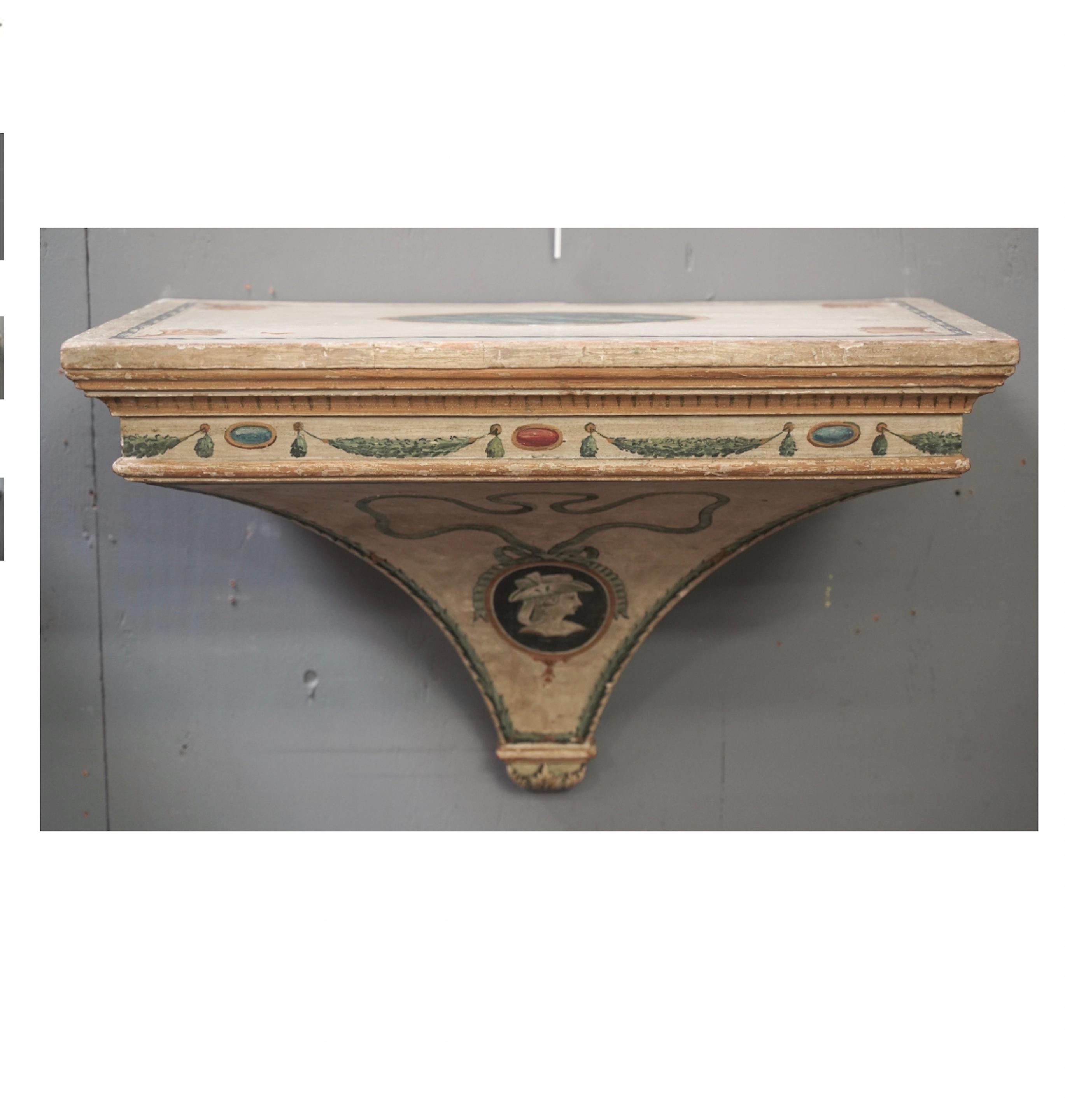 Pair of Venetian, hand painted wooden wall brackets decorated with swags, trompe-l'oeil dentils,  left and right facing portrait medallions, and ribbons.  