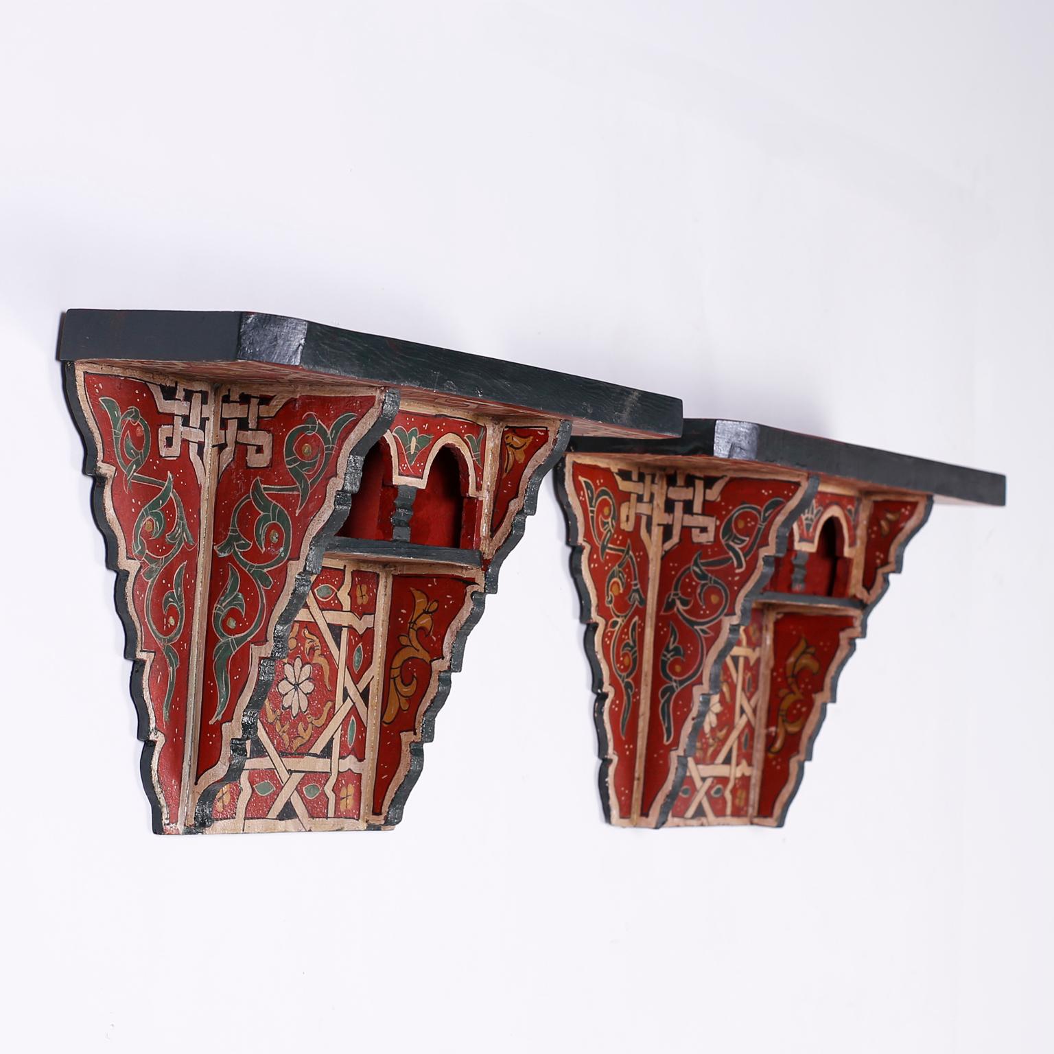 Pair of Moroccan wall shelves crafted in wood with arched nooks and painted in distinctive Mediterranean rustic colors in floral and geometric designs.