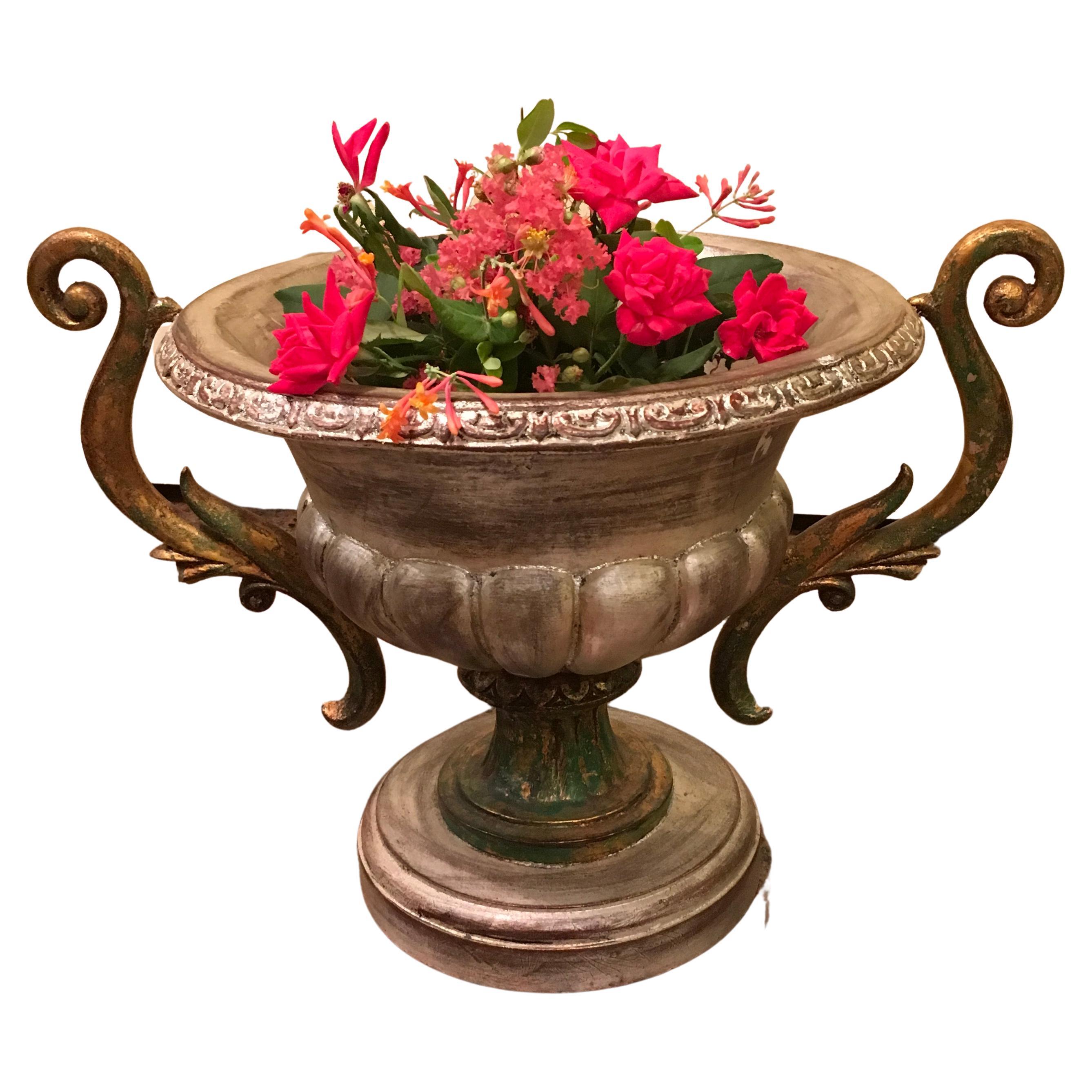 Une paire de vases vintage en bois peint en argent dans le style des anciens kraters grecs, avec de grandes poignées doubles et des bases sur piédestal. Les poignées prennent la forme de rinceaux feuillus. Le bord présente un motif d'inspiration