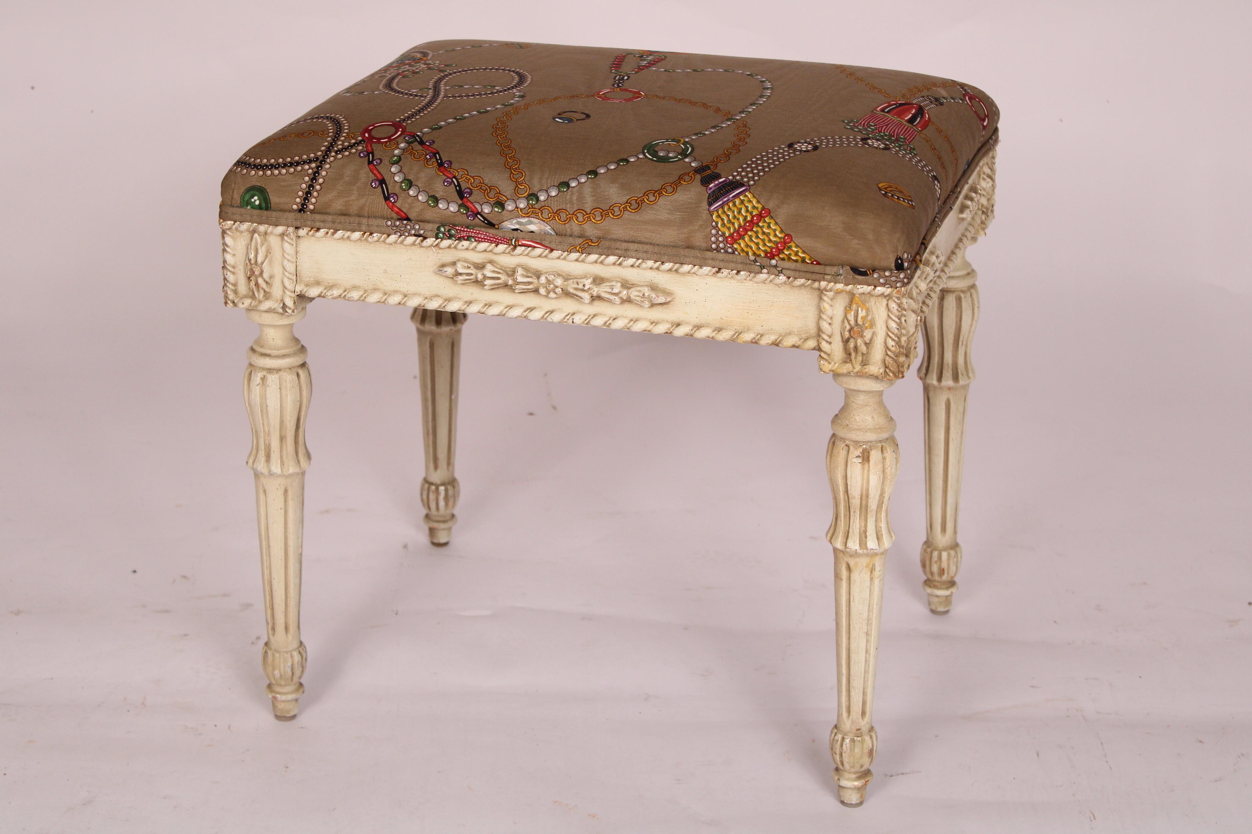 Paire de bancs peints de style Louis XVI, fin du 20e siècle. Les sièges sont rembourrés, les tabliers sont ornés de clochettes en relief et les pieds sont ornés d'une houppe et de cannelures tournées et effilées.