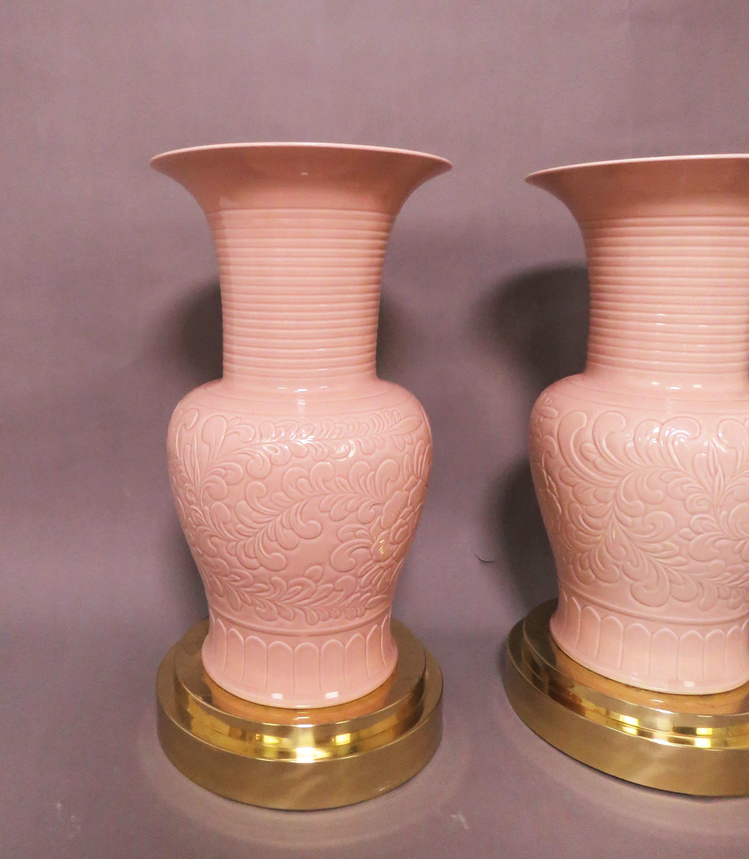 Pair of porcelain palace floor vases in pink conch glaze on brass stands, circa 1980s. Each vase measures: 26.25