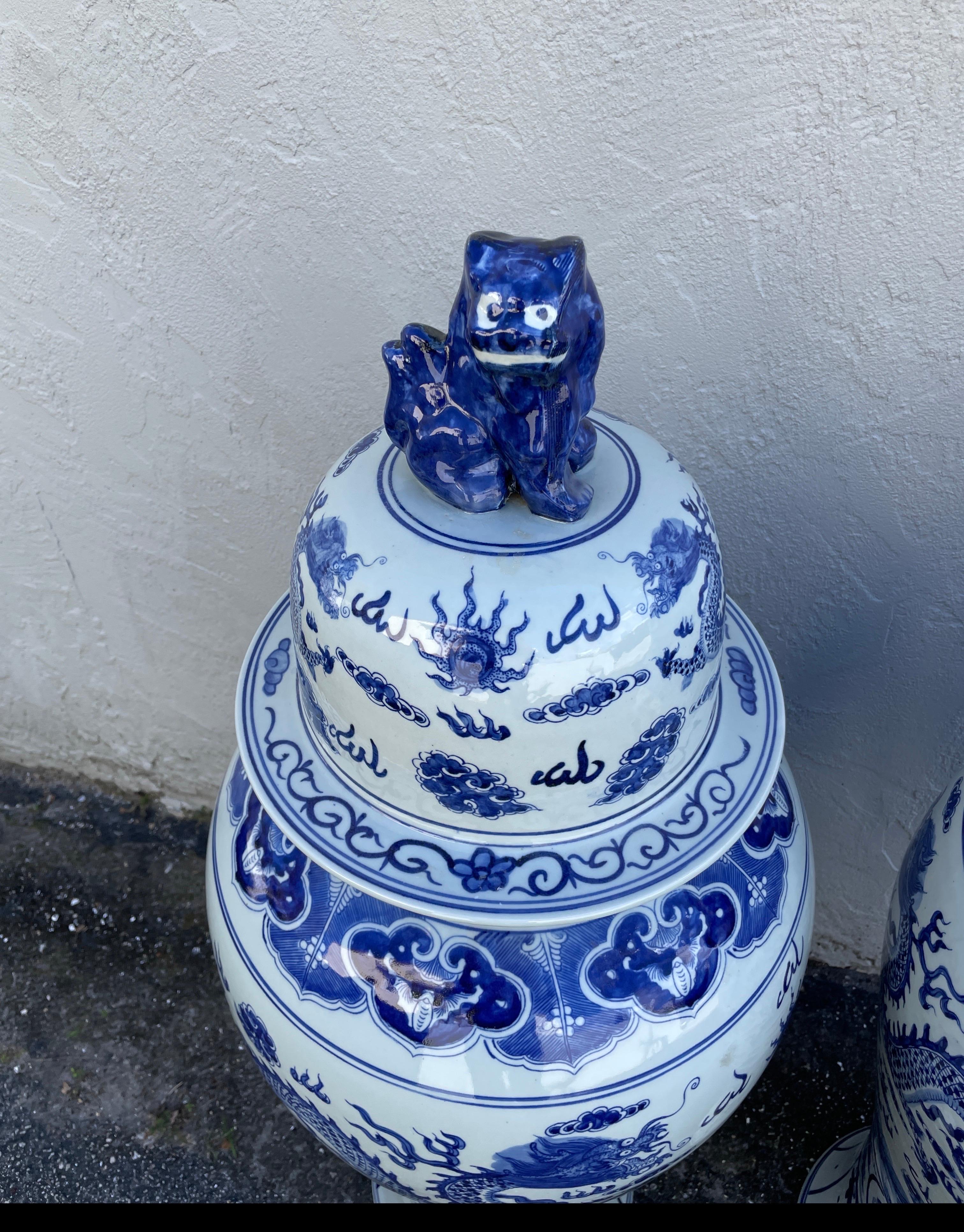 Extraordinaire paire de bocaux à gingembre monumentaux bleus et blancs avec couvercles en forme de chien. Décorée de dragons et de plantes. 