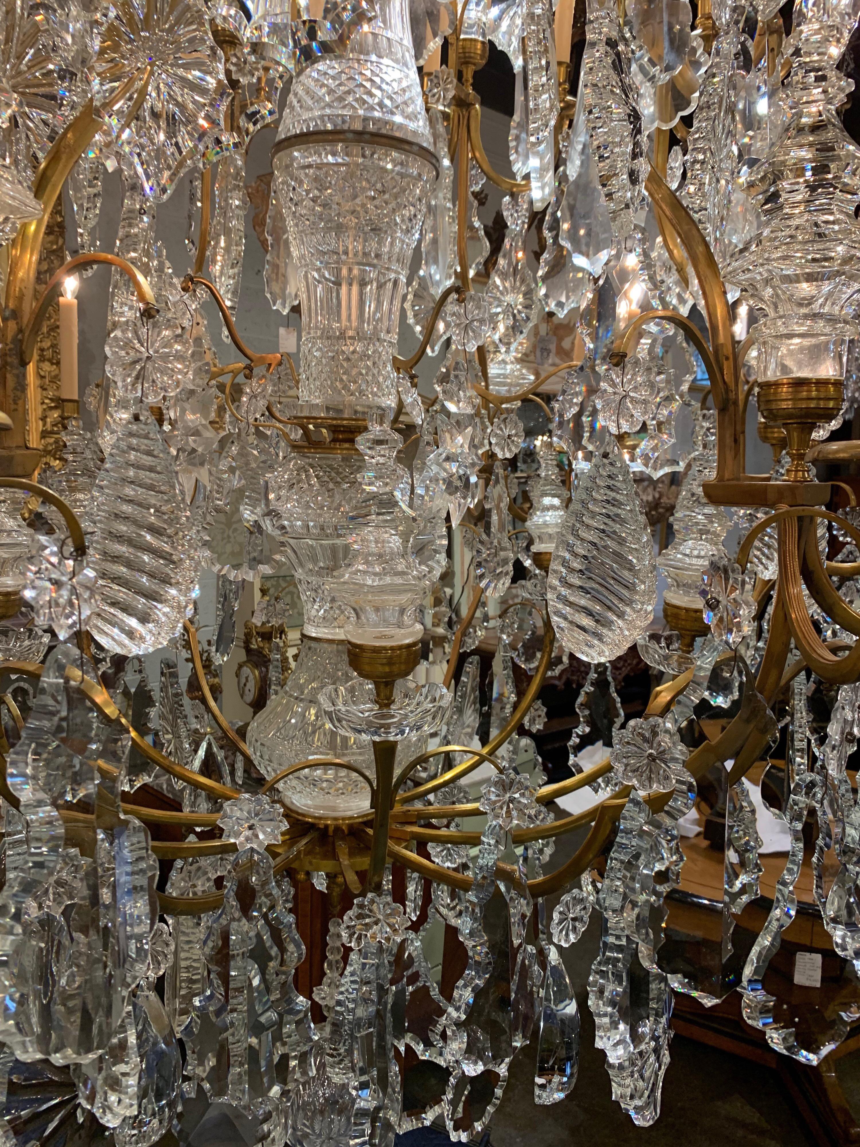 Magnificent pair of palace size Baccarat style crystal and bronze chandeliers. Each has 24 lights and a plethora beautiful glistening crystals. Pictures do not due these justice.   Absolutely stunning and exceptional quality.   