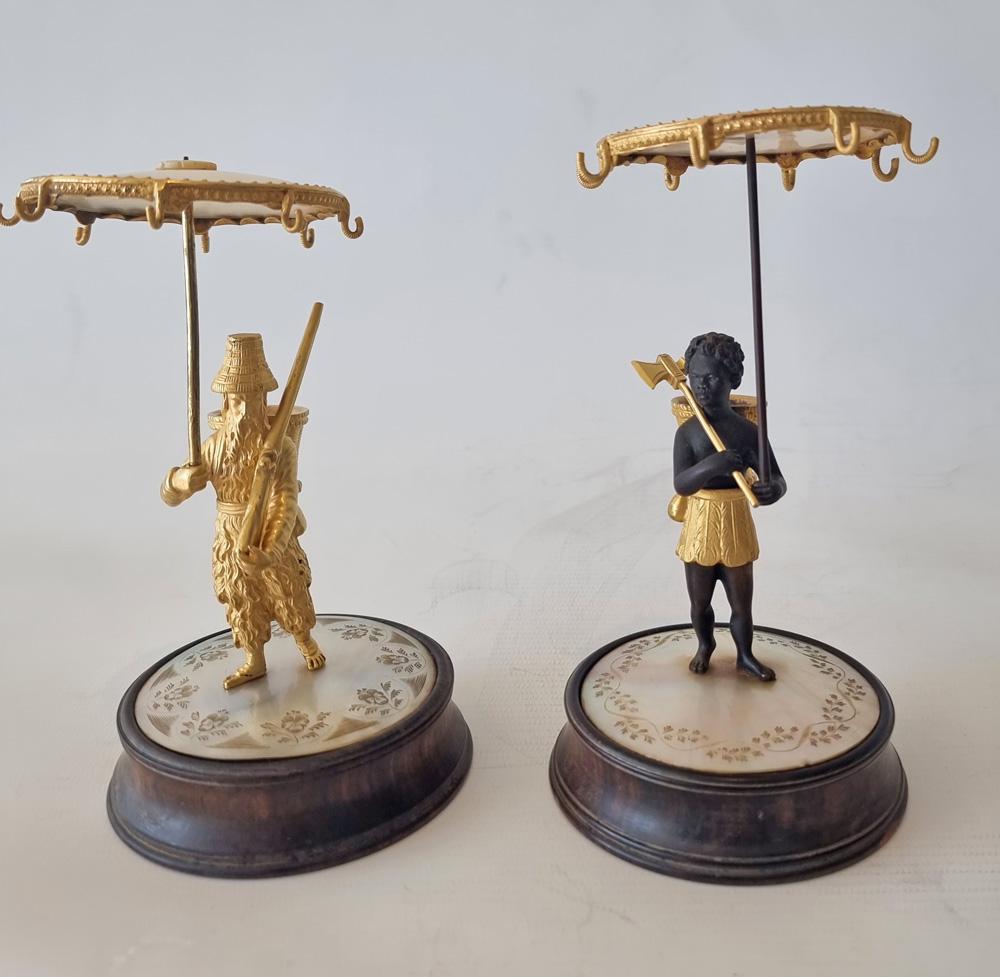 A very rare and fine Charles X period pair of mother of pearl and ormolu ring stands, depicting Robinson Crusoe and Man Friday. Set upon wooden bases with engraved mother of pearl, the figures of Robinson Crusoe and Man Friday depicted holding