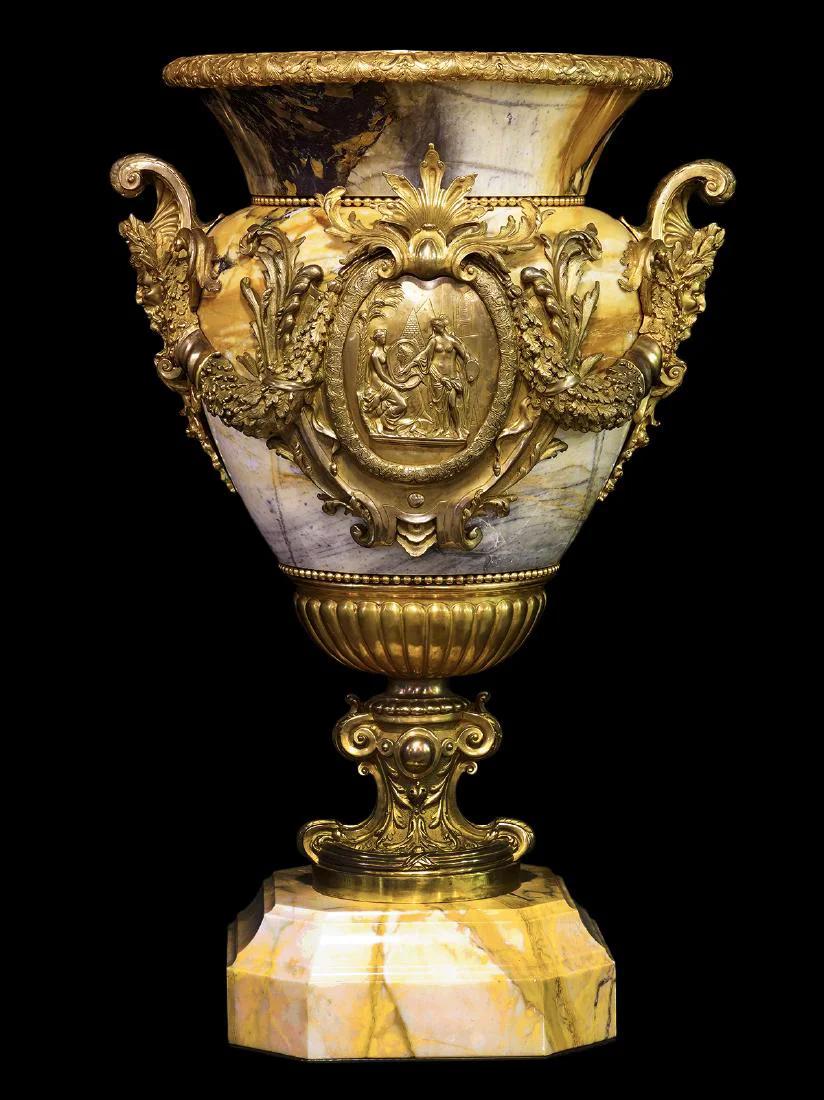 Our pair of palatial urns are carved from Sienna marble with bronze mounts including garland swags, figural plaques at the center and satyr mask handles, and beaded trim at the rims and base. 40 x 26.5 in; 102 x 67 cm.