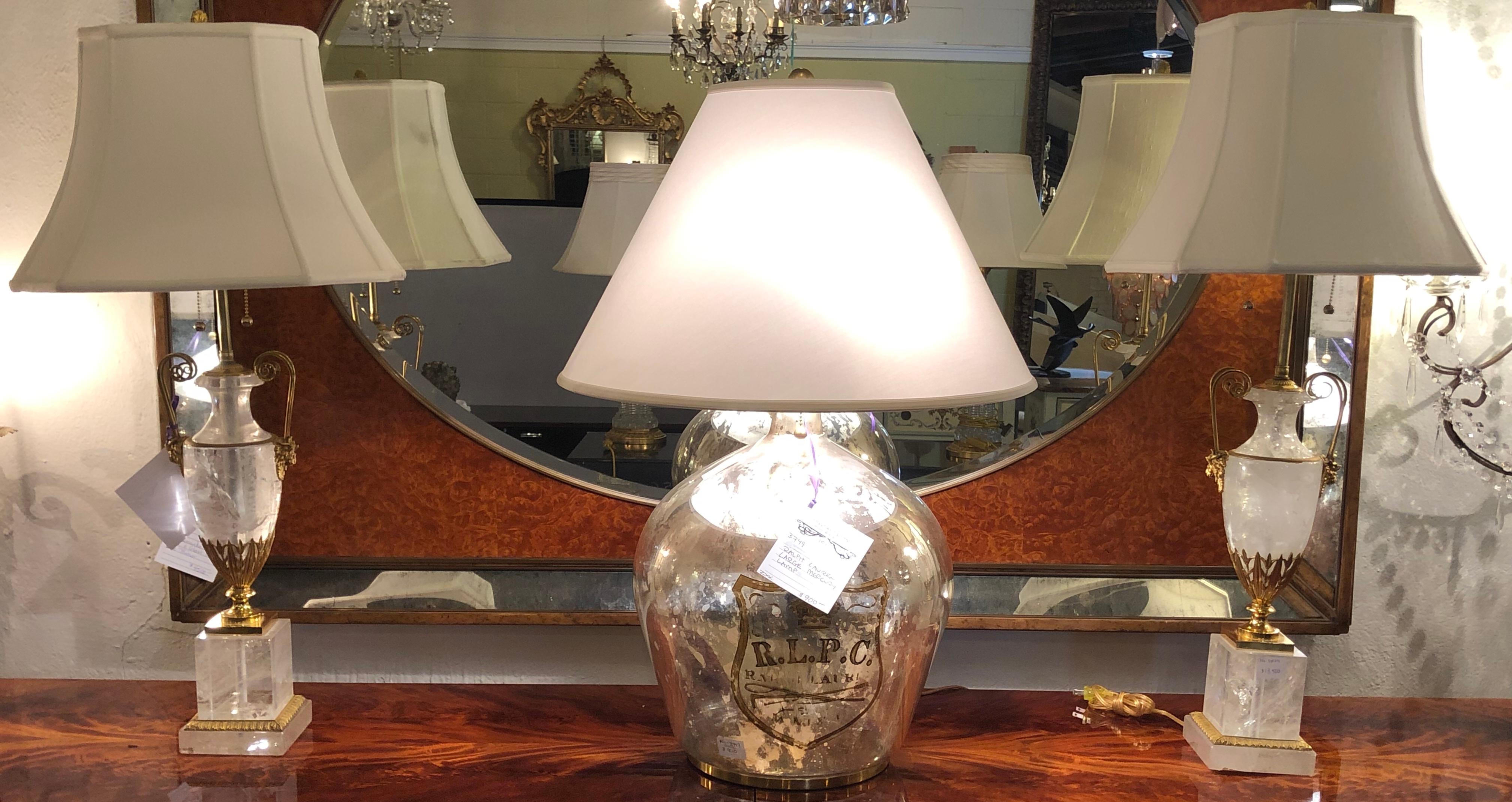 Pair of very large gilt gold and rock crystal urn form table lamps with custom shades. A pair of ormolu mounted rock crystal table lamps with scrolled horned lions mark handles and stepped square bases. A very similar pair of half this size sold in