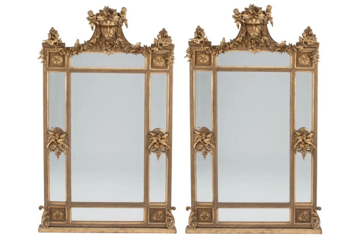 Pair of Monumental Wall or Console Mirrors, Over the Mantle Mirror, 
A magnificent pair of gilt gesso and wood mirrors each having a large rectangular frame depicting carved birds, cherubs with vine and wreath design having roses throughout. 
