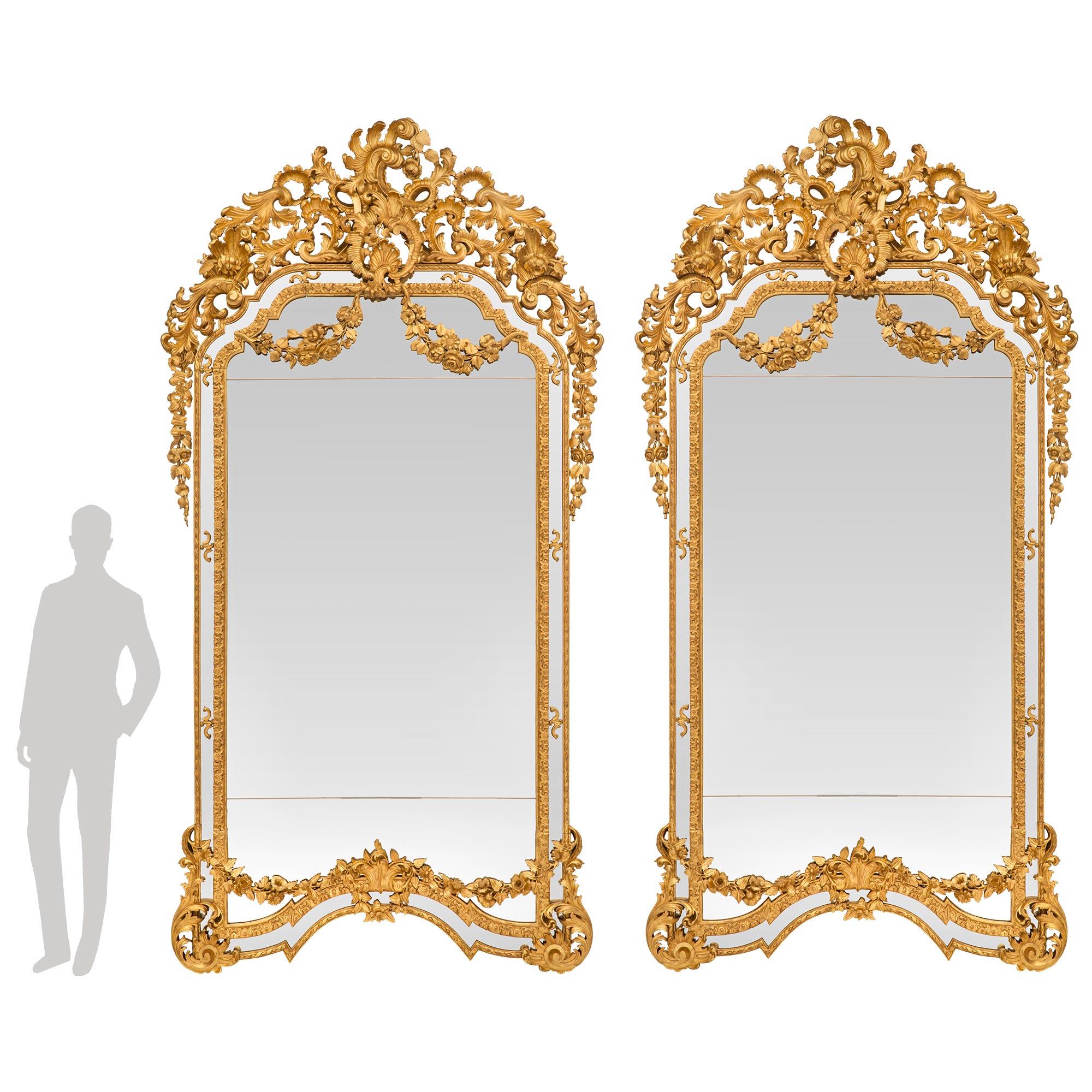 A sensational and very rare pair of palatially scaled Italian mid 19th century Baroque st. double framed giltwood mirrors. Each mirror retains all of its original mirror plates throughout framed within a beautiful mottled foliate band and fine