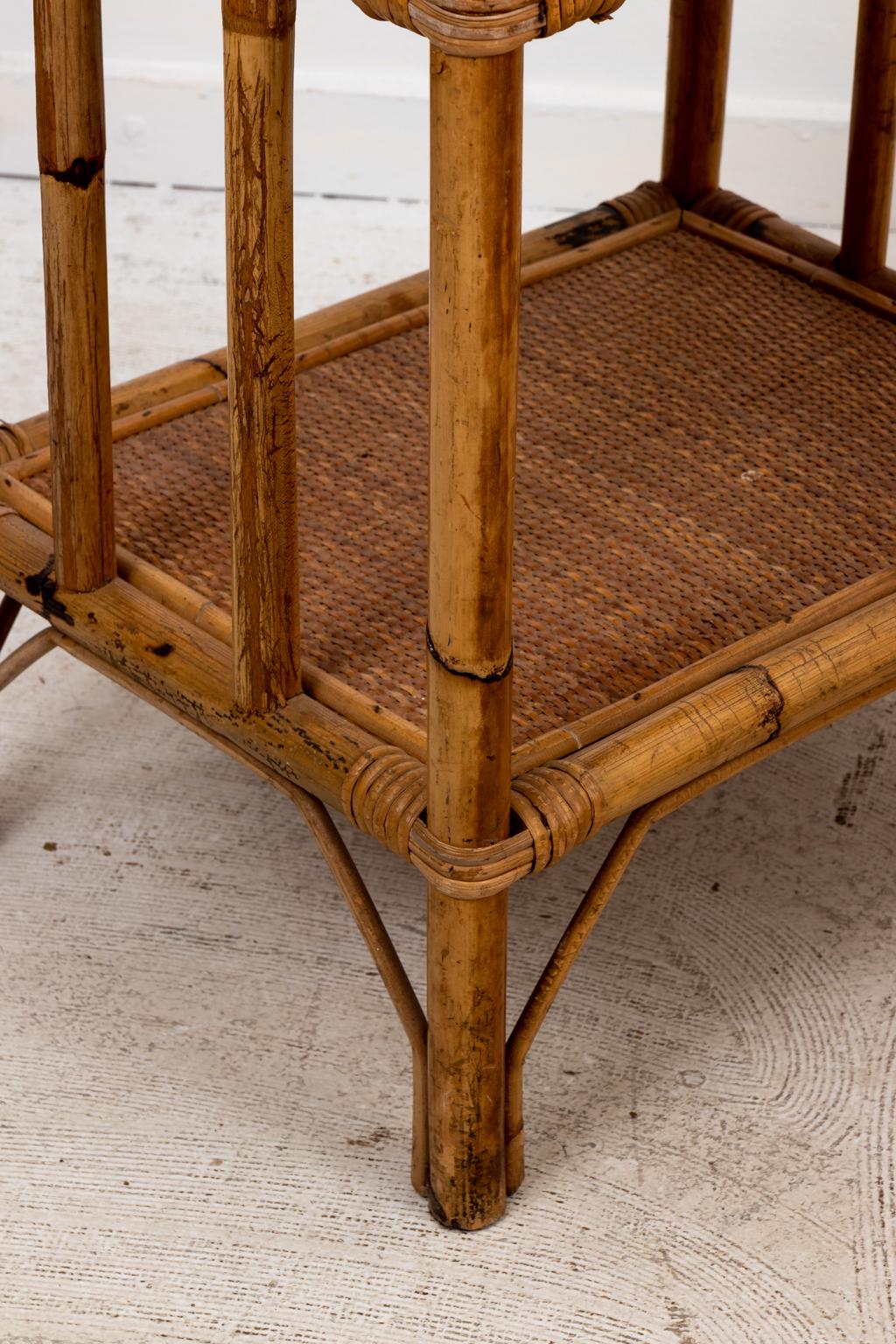Circa 1950s pair of Palm Beach Regency style rattan rectangular two tiered side tables with woven detail on the tabletops. Please note of wear consistent with age including minor finish loss and scratches. Made in Italy.