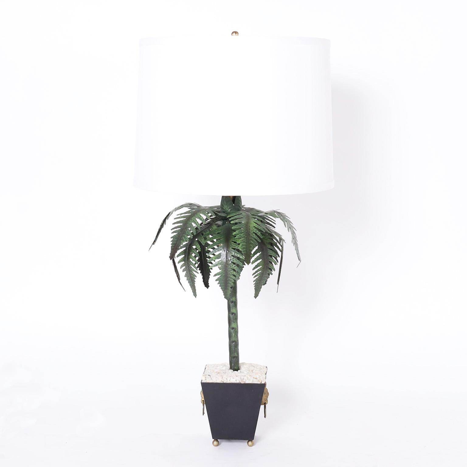 Chic pair of neoclassic style Italian tole table lamps with stylized palm trees in planters toped with white rocks, brass lion heads, and ball feet.
