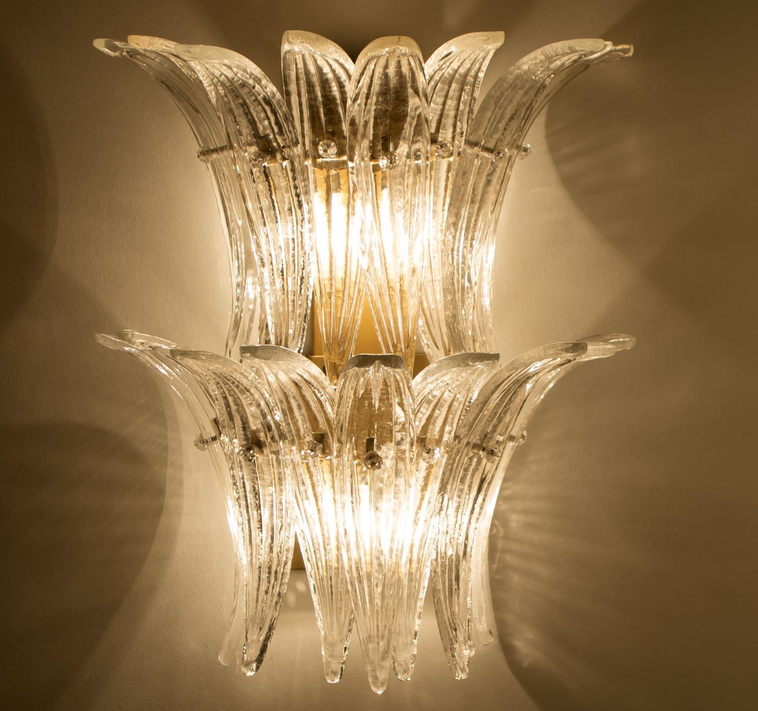 Pair of Beautiful wall lights were designed in the style of Kalmar, featuring a brass base and a rectangular glass cover in opal and clear glass. The glass cover consists of two layers of beautiful palm leaves put together to create a 