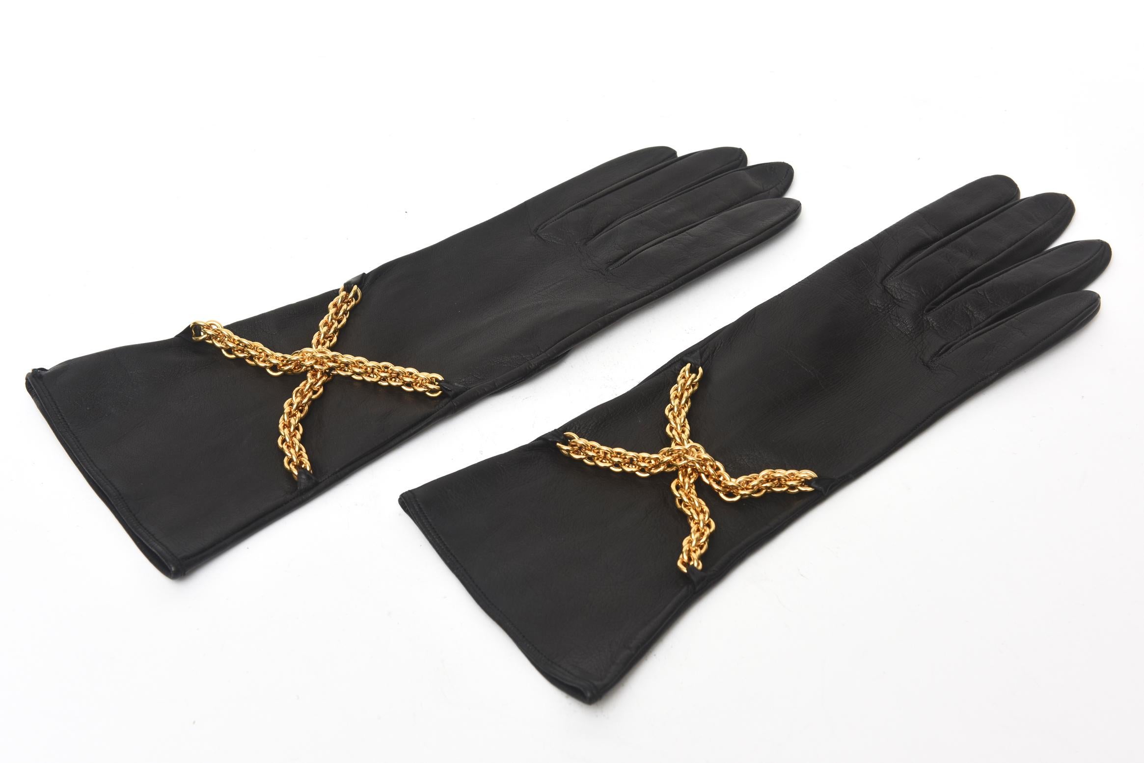 These stunning and truly never worn black leather Paloma Picasso gloves have criss cross brass chains on the front and a black silk lining on the interior. They are a size 6.5 as shown in the photos. They have the Paloma label inside and were made