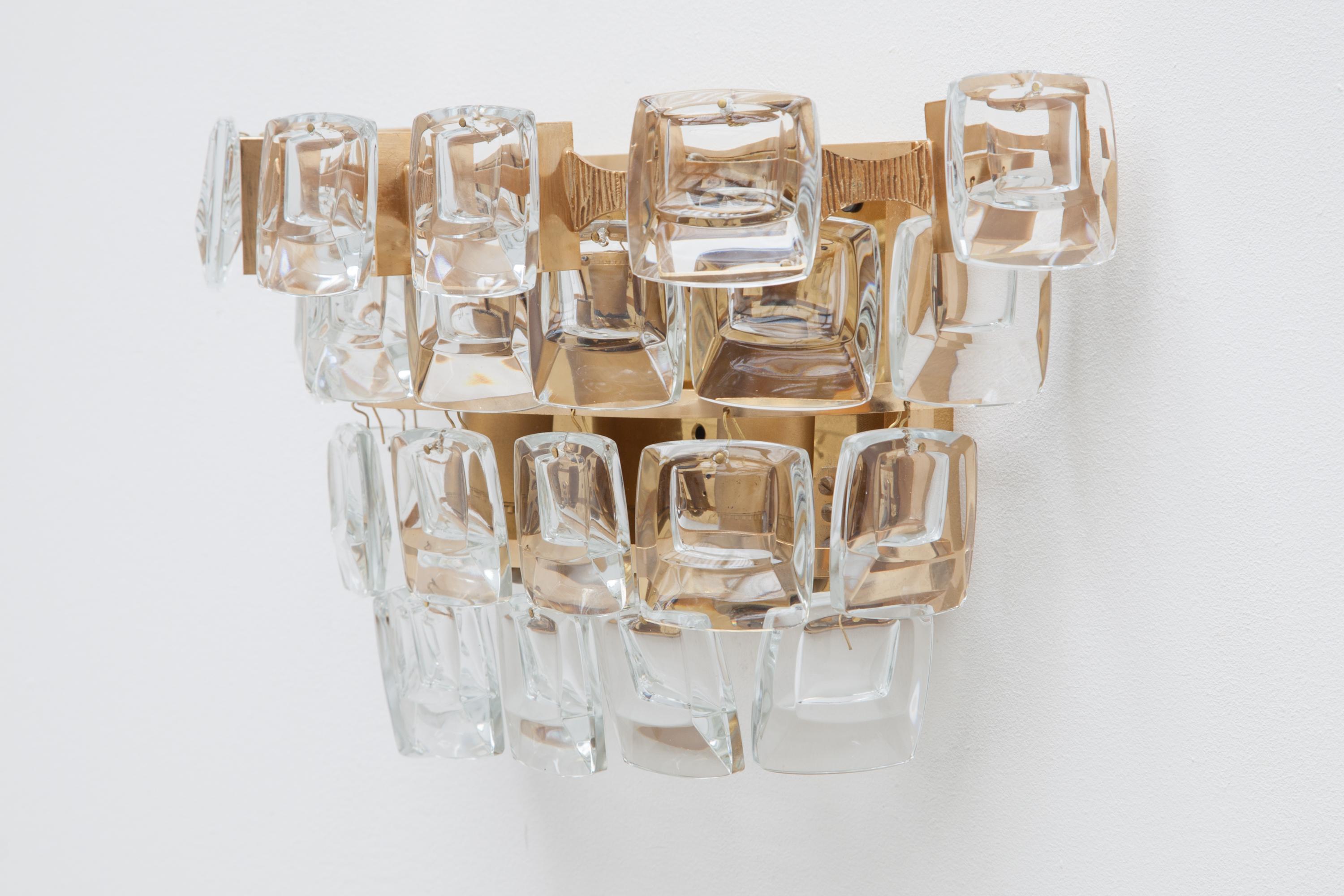 A set of 1950s wall lights, sconces by Palme and Walter, Germany, labeled. Features four tiers of square glass crystals on a textured Brutalist brass frame.Lit by three bulbs. Four sets available.