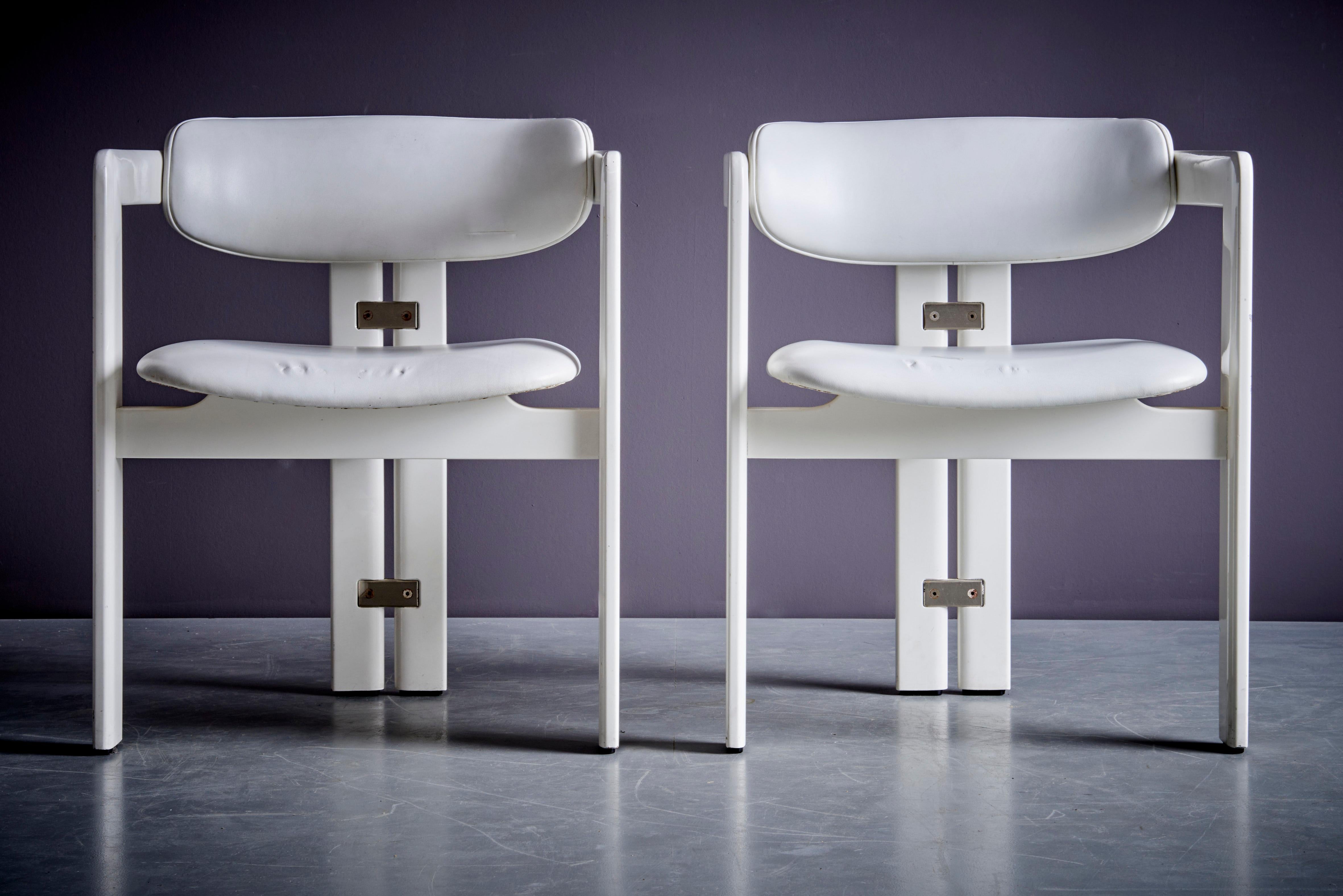 Queste poltrone Pamplona, disegnate da Augusto Savini per Pozzi, hanno una struttura in legno laccato bianco e un rivestimento in pelle bianca sulla seduta e sullo schienale. Il suo design pulito è caratterizzato da linee decise, con le gambe