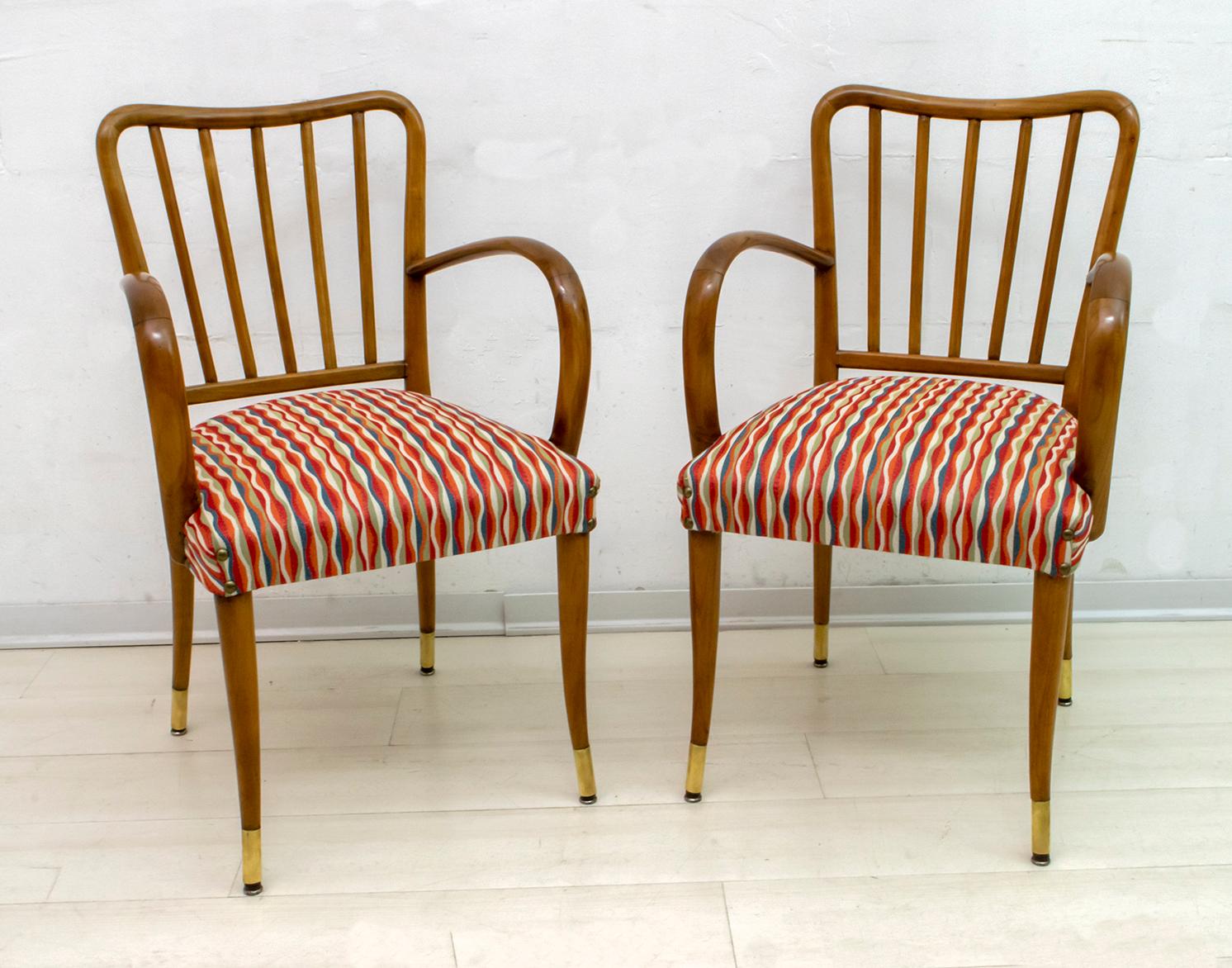 Beautiful pair of chairs with armrests, made by Paolo Buffa in 1950. The structure in curved, patinated wood, the legs with brass terminals, the covering has been redone in a beautiful 1950s style fabric.