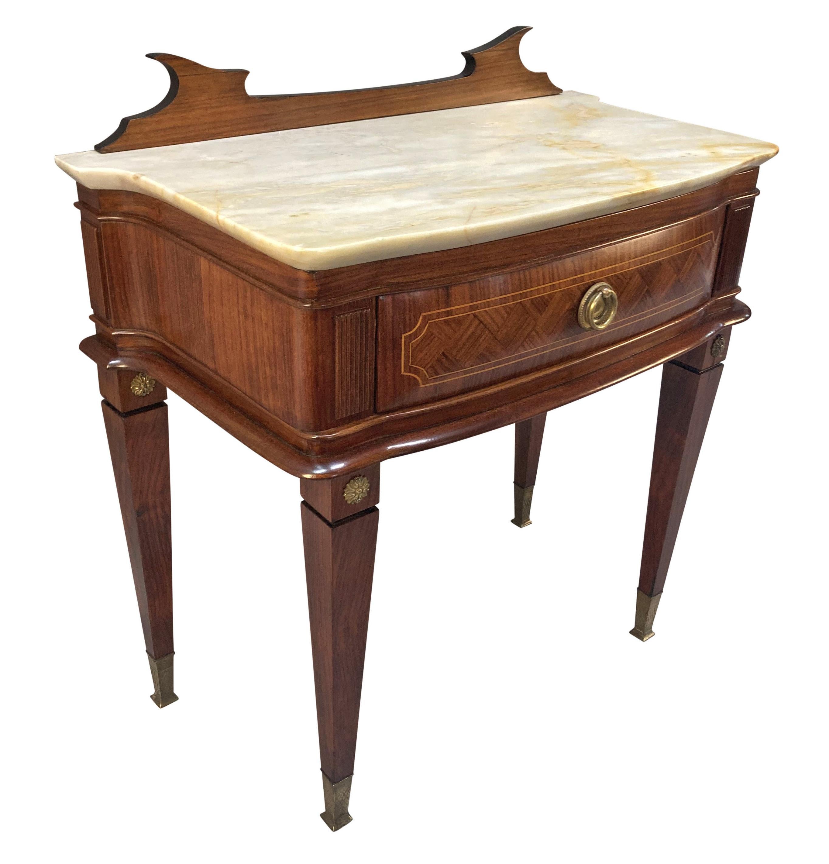 A pair of Italian Mid-Century night stands by Paolo Buffa with frieze drawers. In the Neo-Classical manner, with marquetry, shaped cream marble tops and brass sabot and handles.