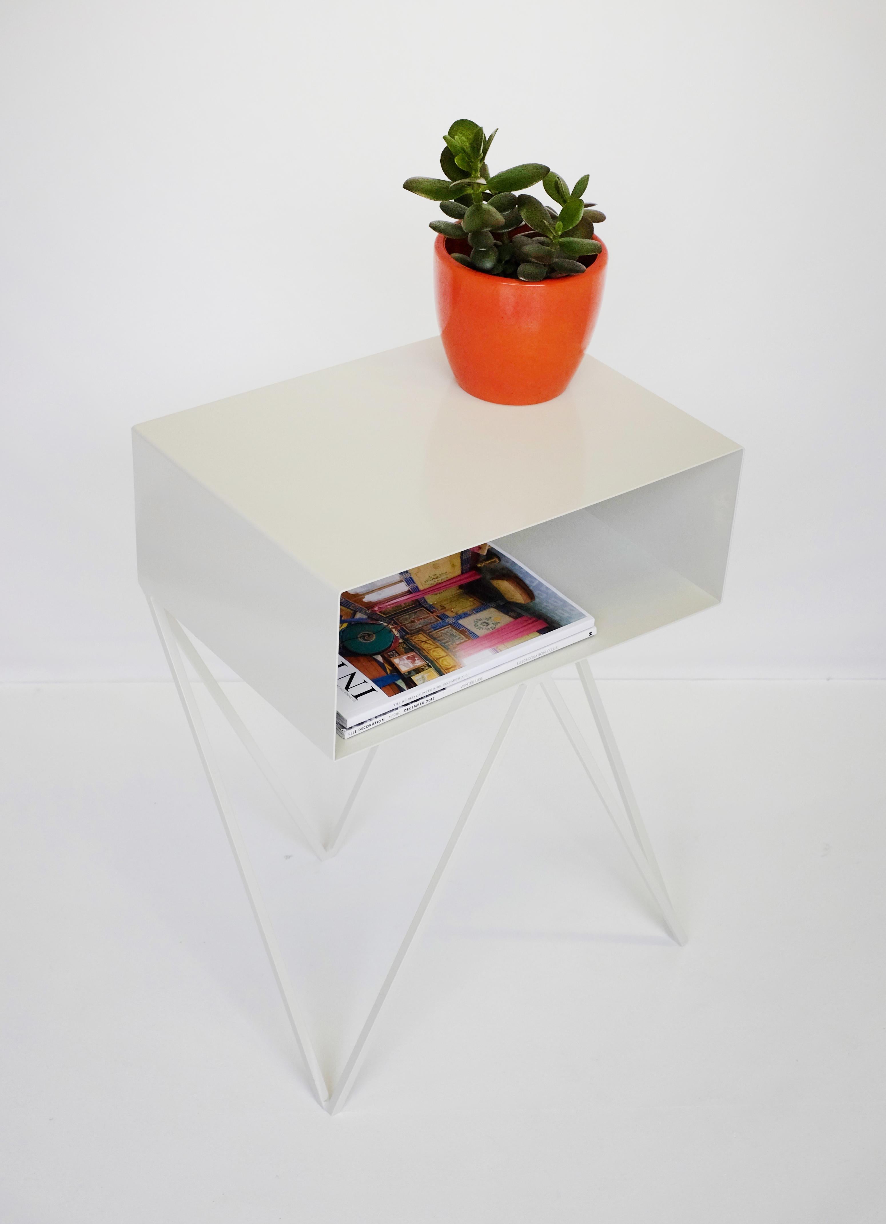 Une paire d'élégantes tables de chevet Robot. La table d'appoint Robot comporte une étagère ouverte sur des pieds en zigzag. Un design amusant et fonctionnel fait d'acier solide, recouvert d'un revêtement en poudre blanc papier. Les lignes épurées