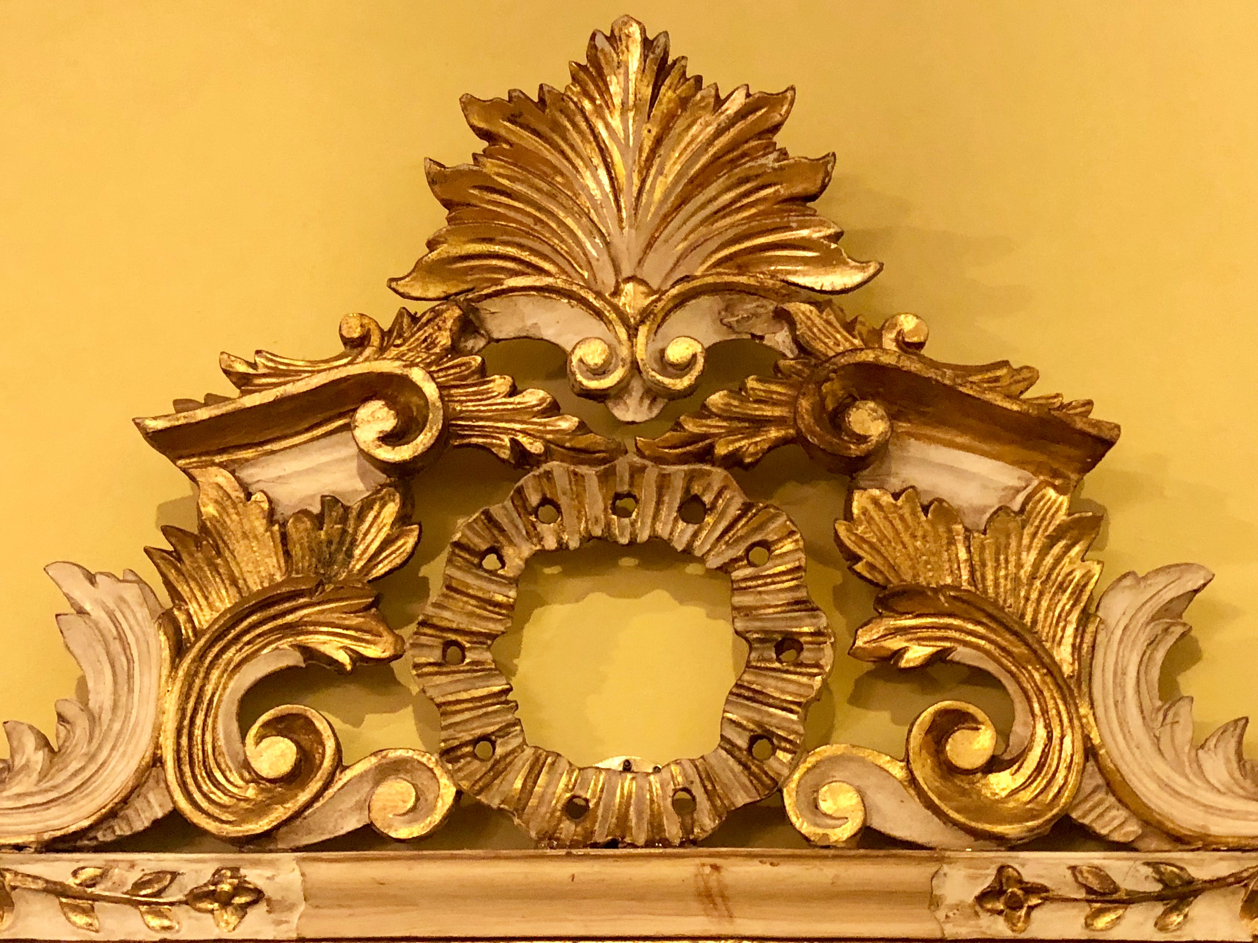 Pair of parcel-gilt mirrors. Beautifully carved representing the ideal of the Rococo period which symbolizes delicacy and romantic style along with feminine and light details. Italian Rococo style is represented in its fullest with the features of