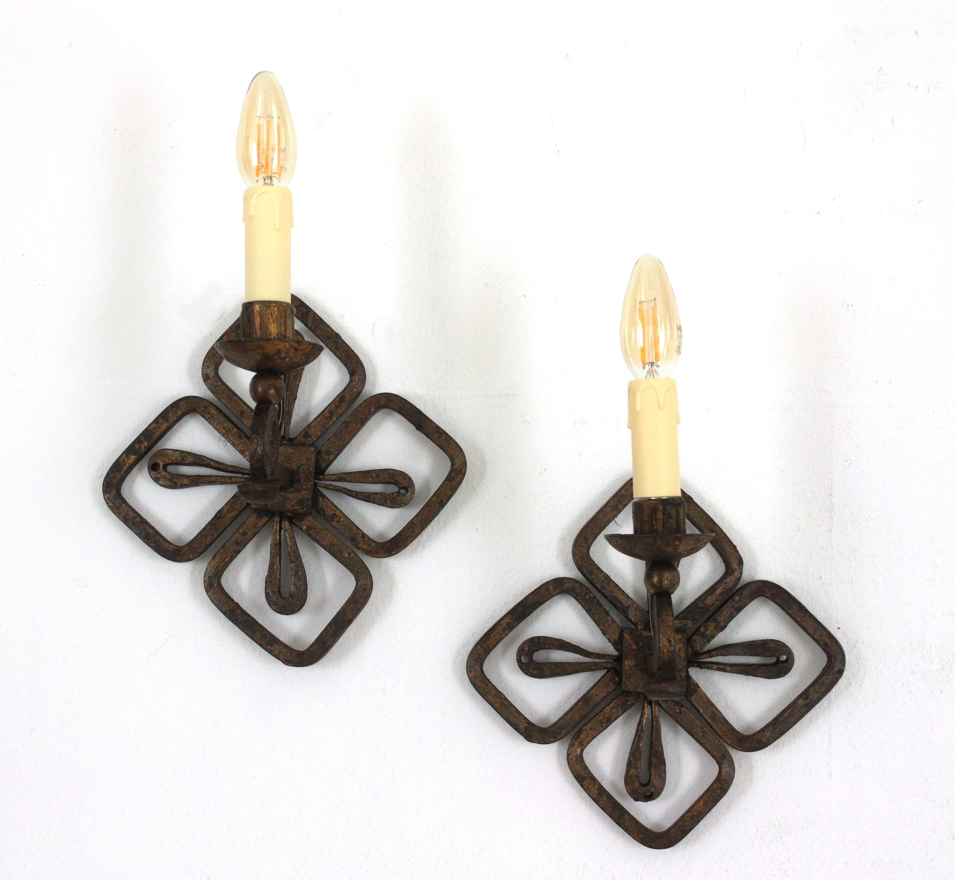 French 1940s Wall Lights, Hand Forged Iron
Elegant pair of wrought iron wall sconces with gold leaf gilding and Fleur de Lis Design, France, 1940s.
These hand forged light fixtures feature a fleur-de-lis shaped backplate holding an scroll ended arm