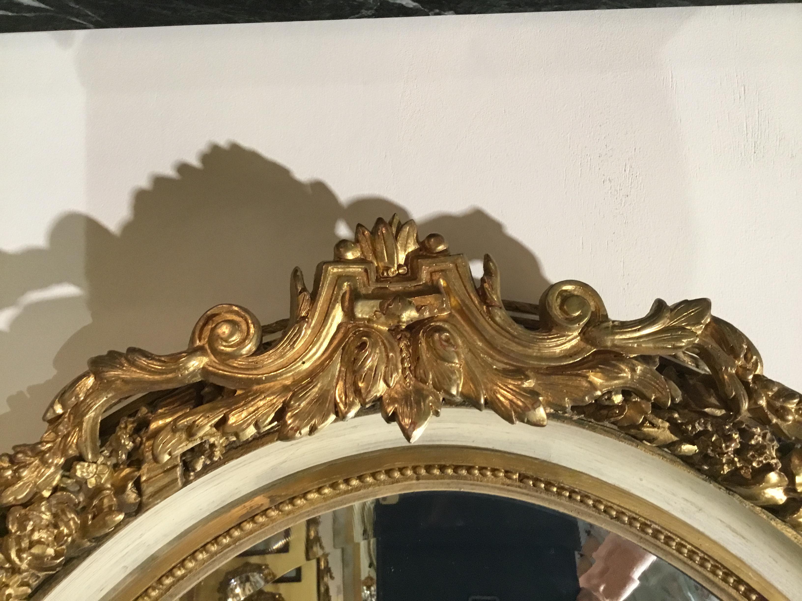 French Pair of Parcel Paint and Parcel Gilt Beveled Oval Mirrors, with Bird Carvings