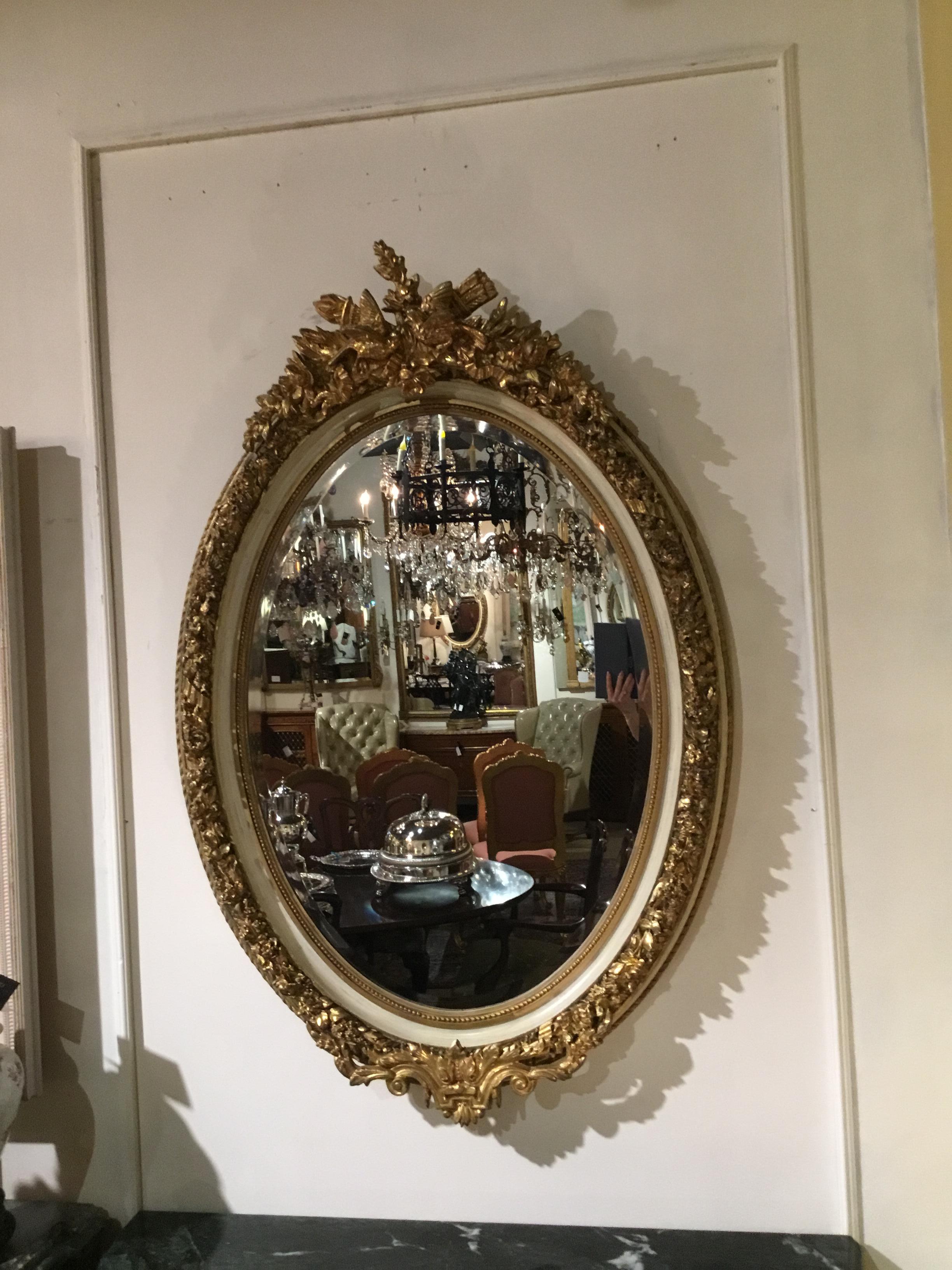 20th Century Pair of Parcel Paint and Parcel Gilt Beveled Oval Mirrors, with Bird Carvings