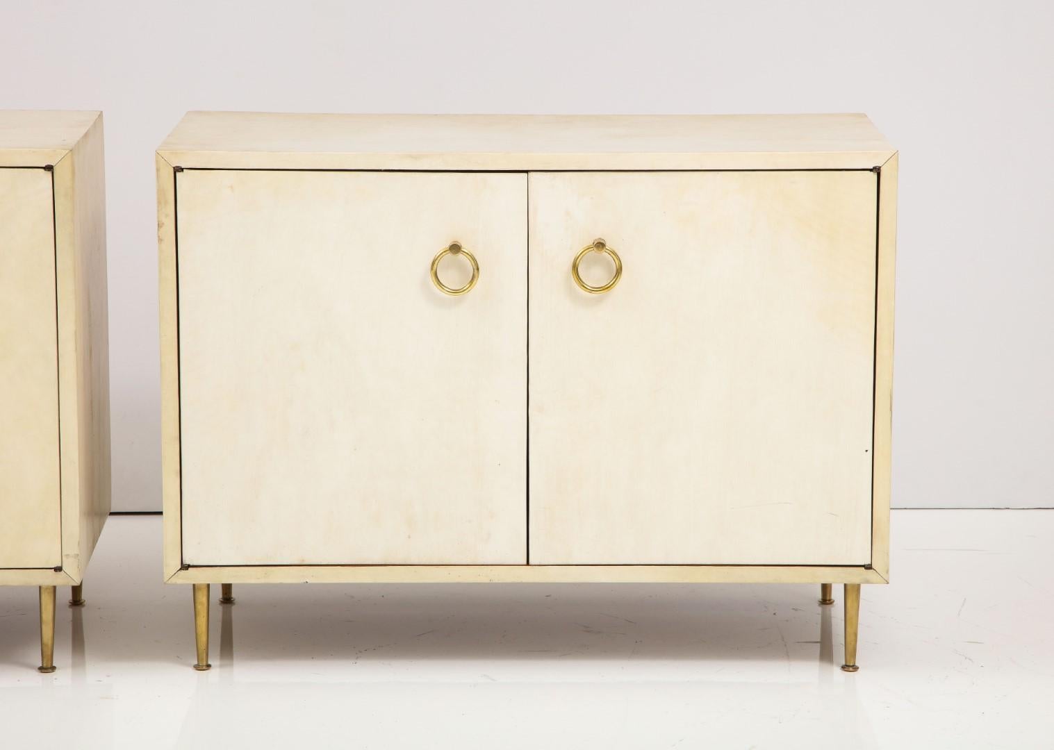 A wonderful Pair of Parchment chests in the Manner of Gio Ponti. The chests contain a shelf and stand on brass tapering legs.