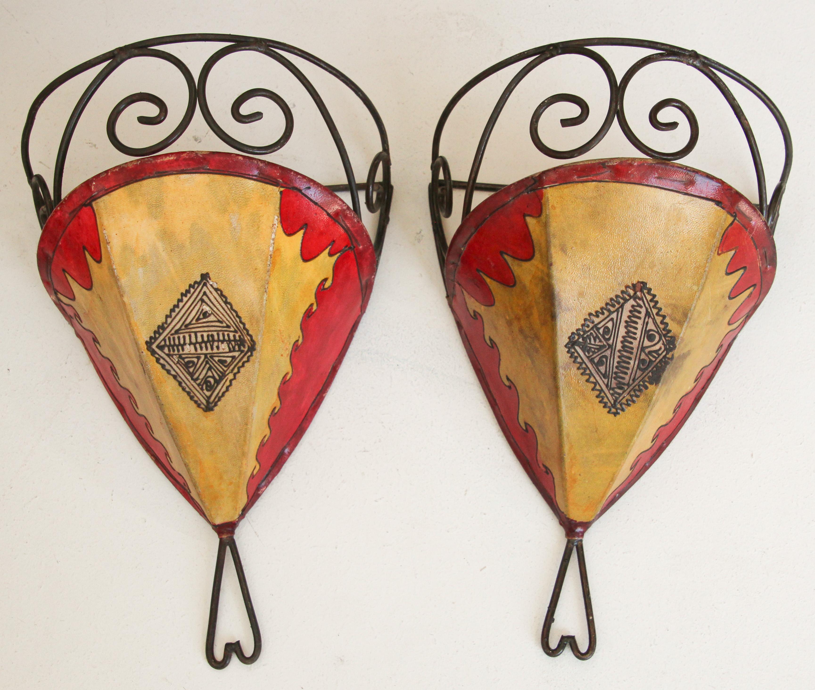 African tribal art parchment wall shade sconce featuring a large curved hide form stitched on iron and hand painted surface.
These Moroccan art pieces could be used as wall lamp shade.
Iron frame covered with hide parchment which has been hand