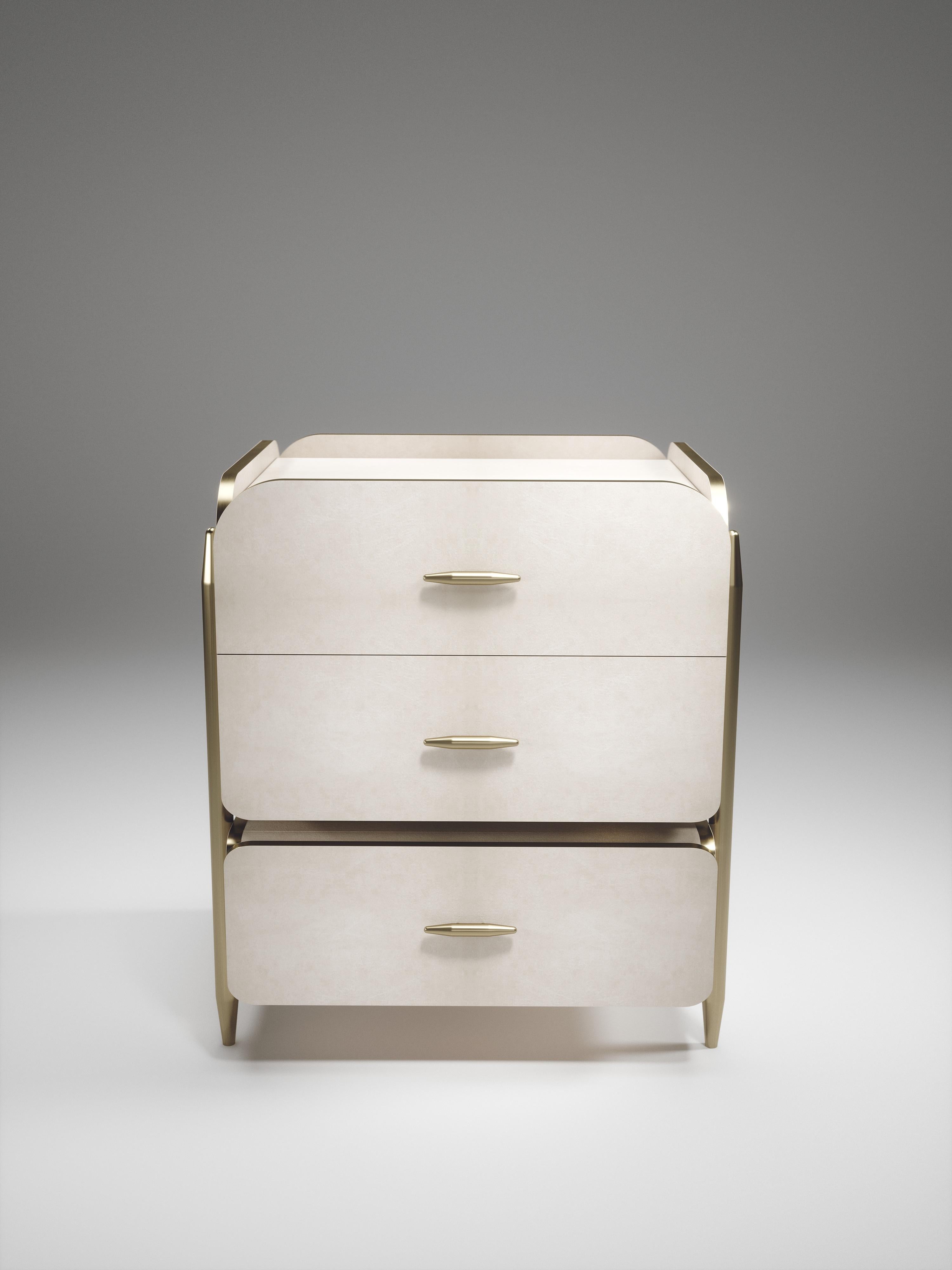 The pair of Dandy square bedside table by Kifu Paris is an elegant and a luxurious home accent, inlaid in cream parchment with bronze-patina brass details. This piece includes 3 drawers total and the interiors are inlaid in gemelina wood veneer.
