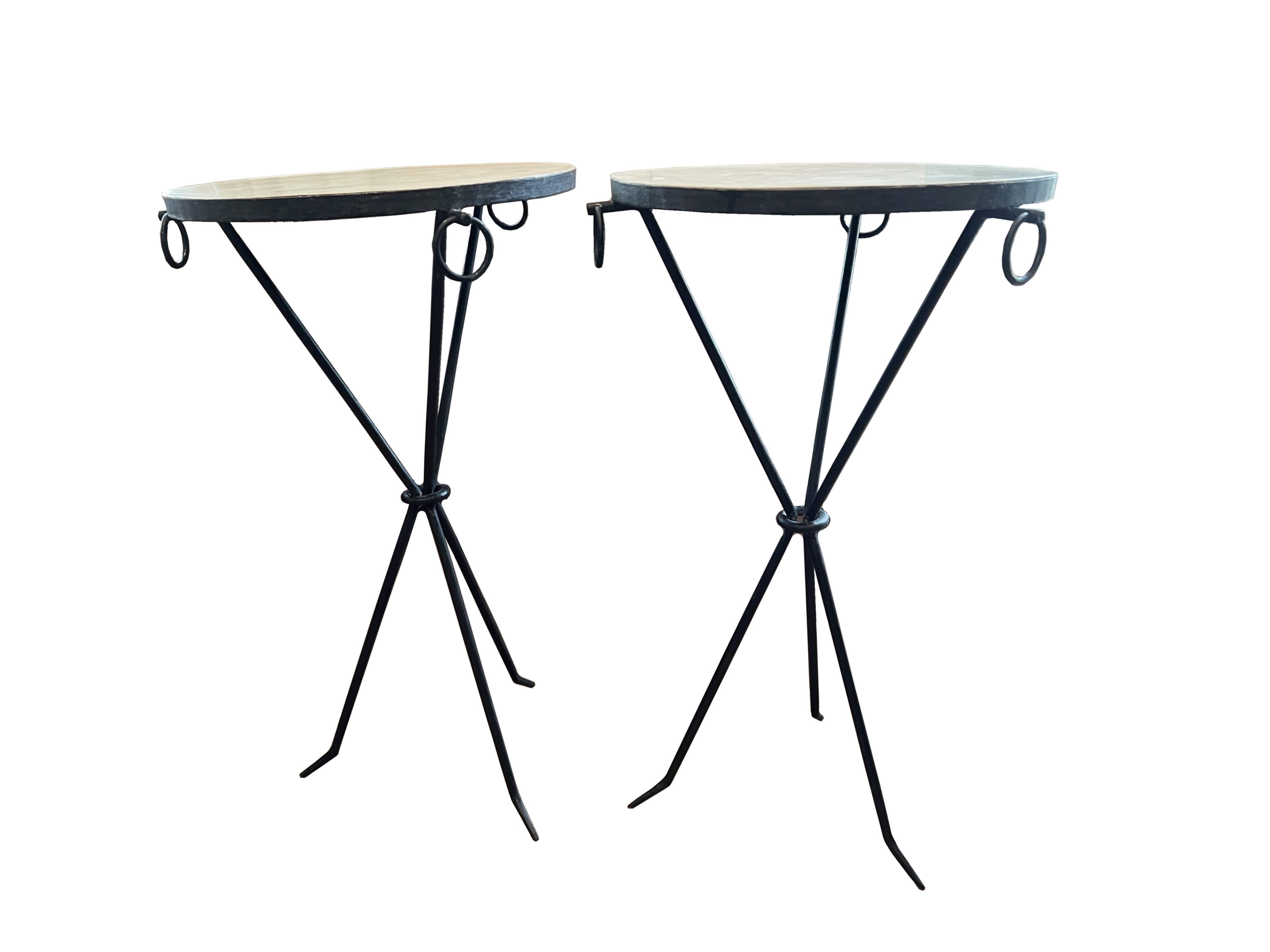 Introduce a touch of Parisian elegance to your home with this pair of black iron drink tables, featuring exquisite parchment tops adorned with sophisticated ring detailing. Inspired by the iconic Jean Michel Frank, on of the most revered French