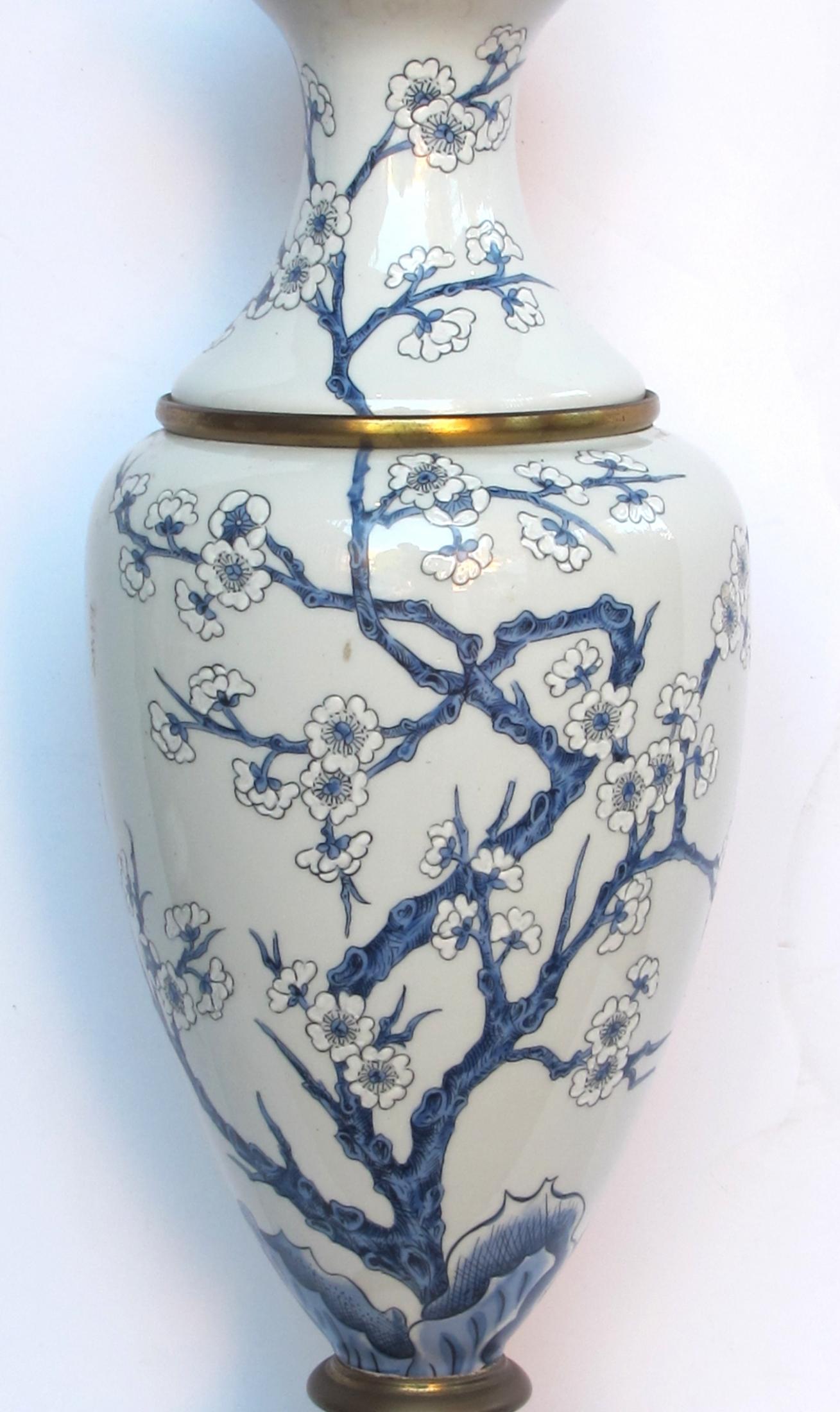 Each lamp decorated with meandering branchwork and cherry blossoms; underside with under-glaze blue stamp 'Porcelaine de Paris, france, fondee en 1773'.