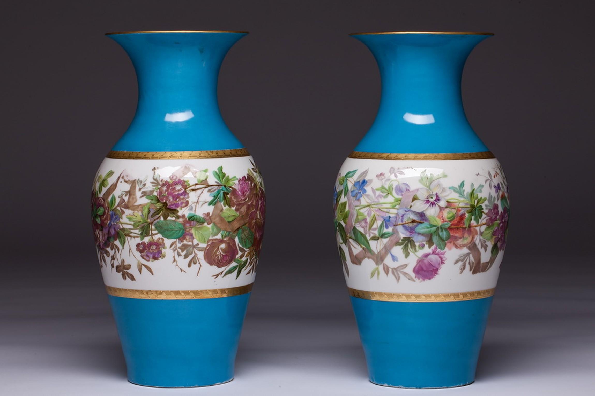 Each of the baluster form vases has a cylindrical neck and everted rim and are painted with floral bouquets on a white ground. On the reverse, each has a large single flower specimen.