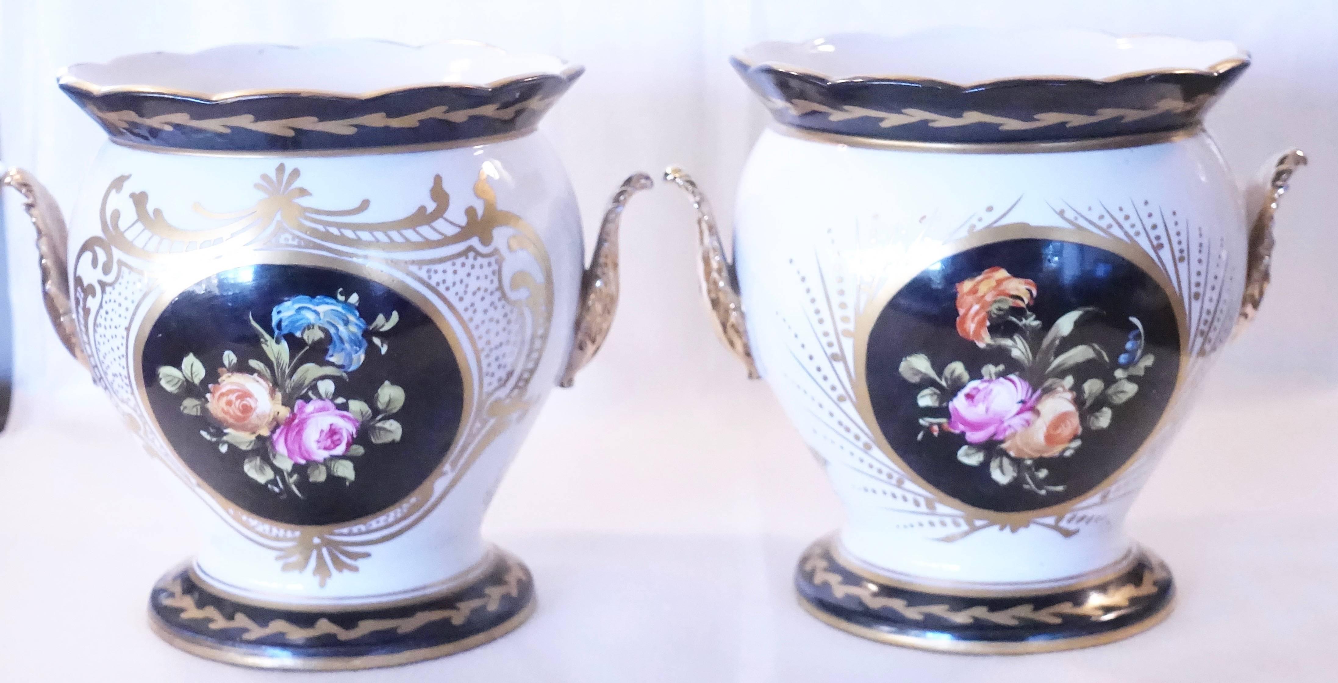 Very nice pair of hand-painted Paris Porcelain planters\cachepots with hand-painted flowers on both sides, the two sides have gold cartouche that are of differing design and gilt acanthus leaf handles, French, circa 1880.