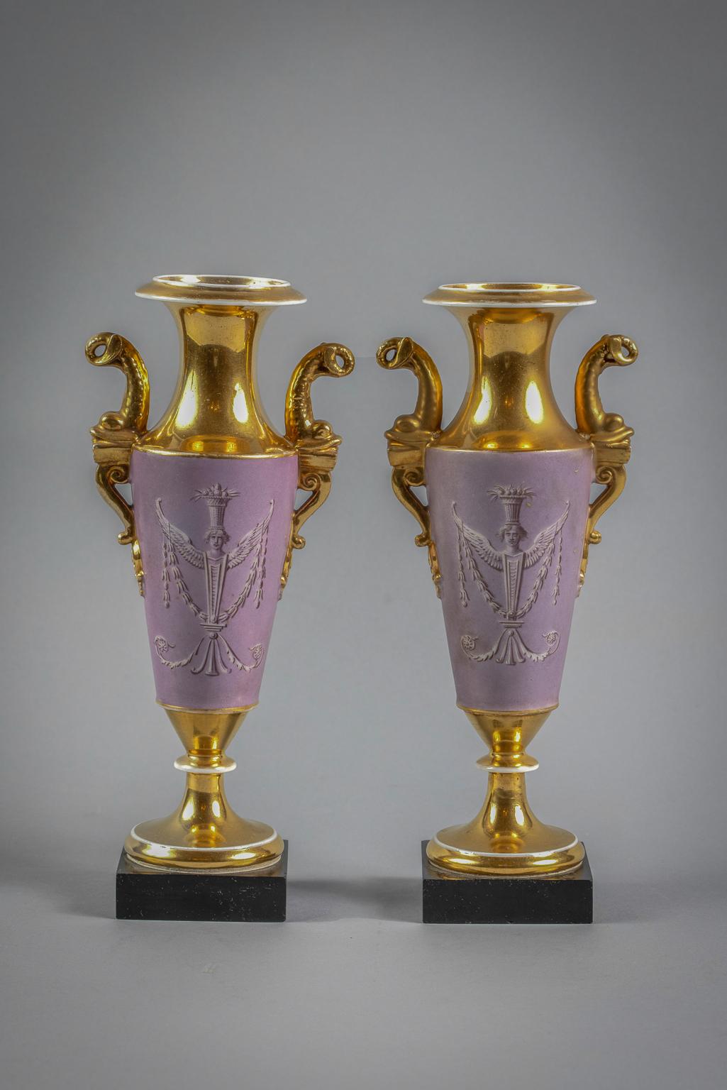 Decorated with dolphin handles, and swans within a gilt and puce lined cartouches and the reverse with caryatid figures balancing fruits.