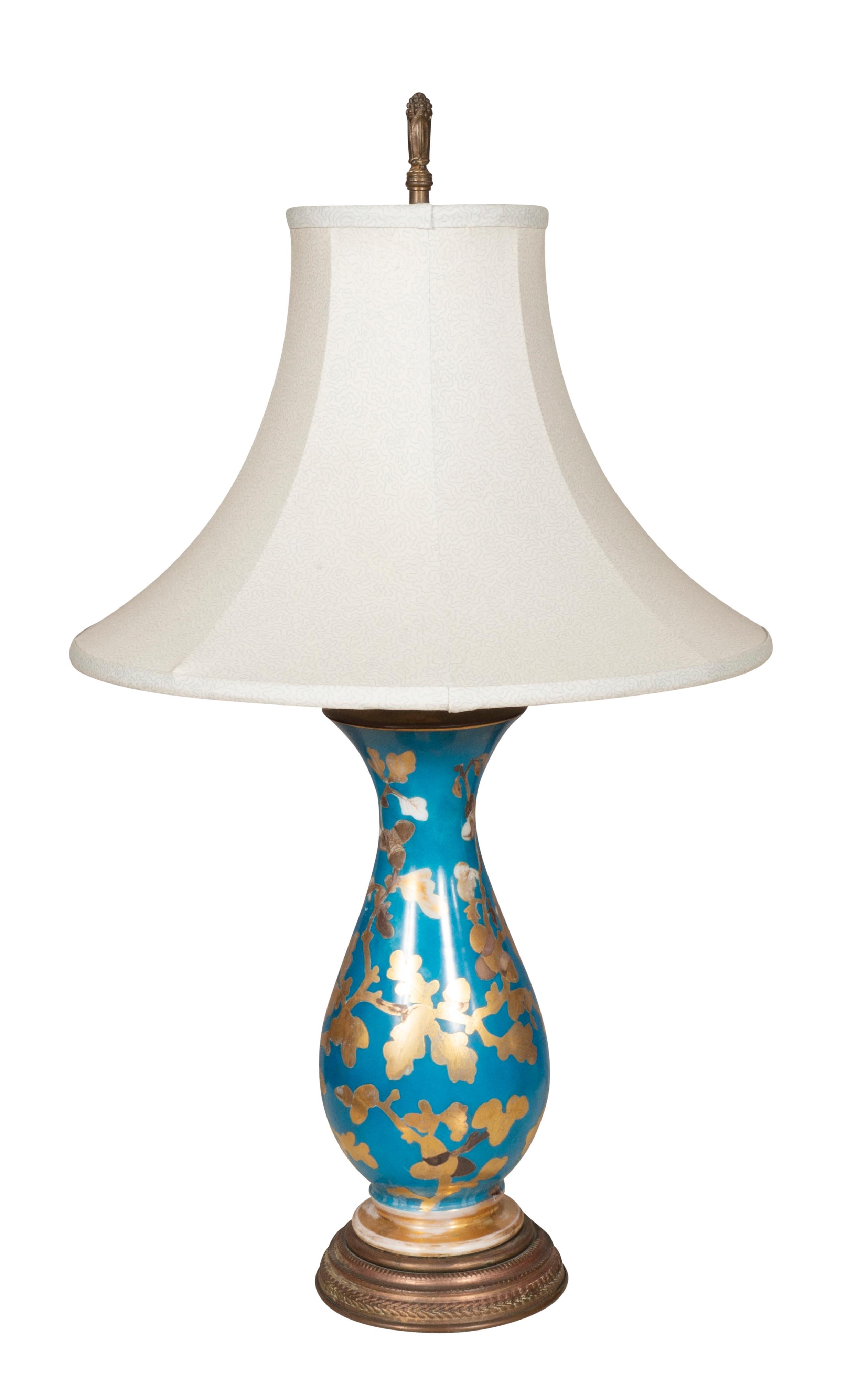 Baluster form with a blue ground with gold trailing leaves. Conforming brass base. Single light. With shades if wanted.