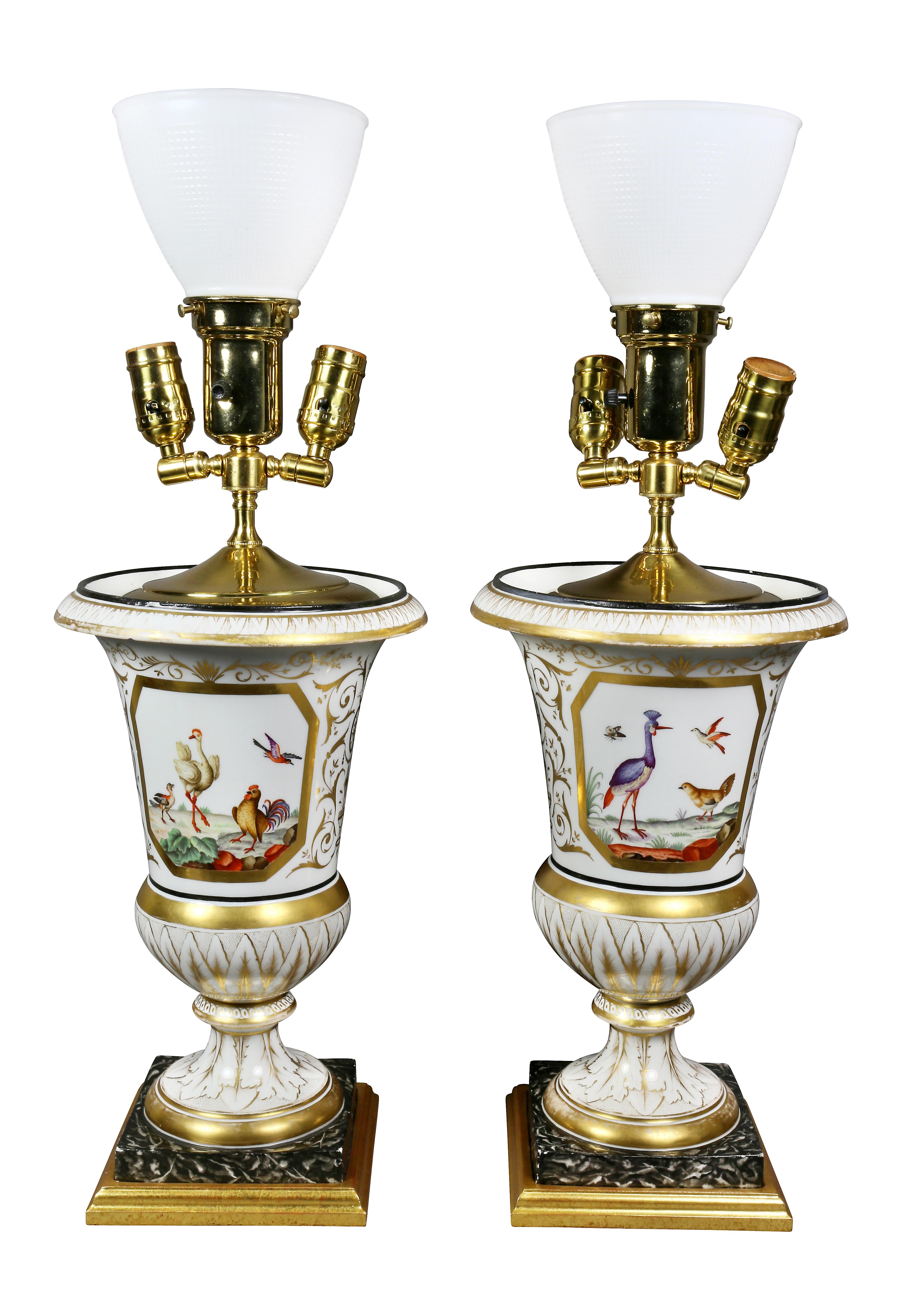 Vases later converted to lamps beautifully painted with a fruit cornucopia on one side and exotic birds on the other. Faux marble socle set in a giltwood base.