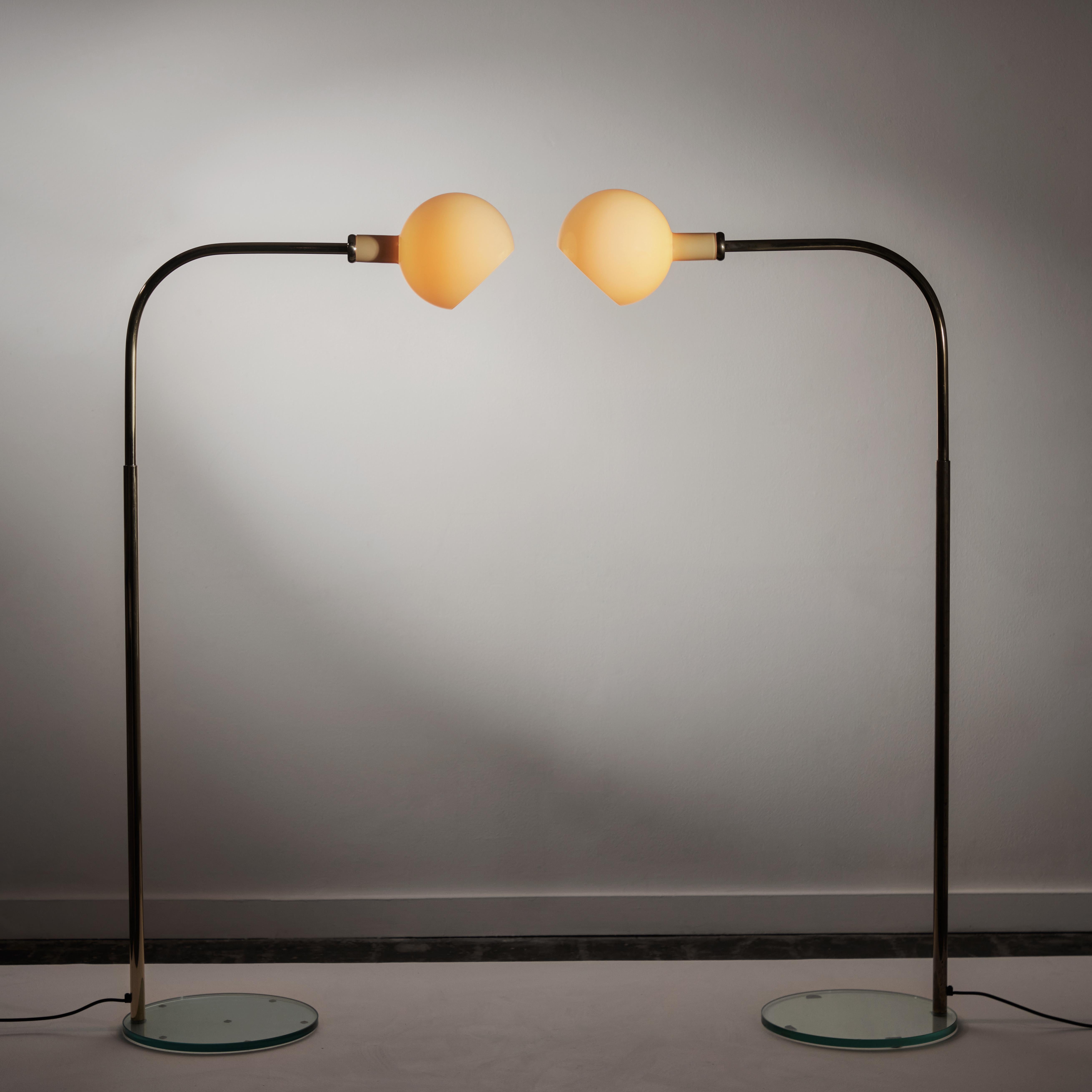 Pair of Parola floor lamps by Gae Aulenti and Piero Castiglioni. Designed and manufactured in Italy, circa 1980's. Glass, brass. Original EU cord. We recommend on E14 bulb per fixture. Bulbs not included. SOLD AS A PAIR ONLY!.