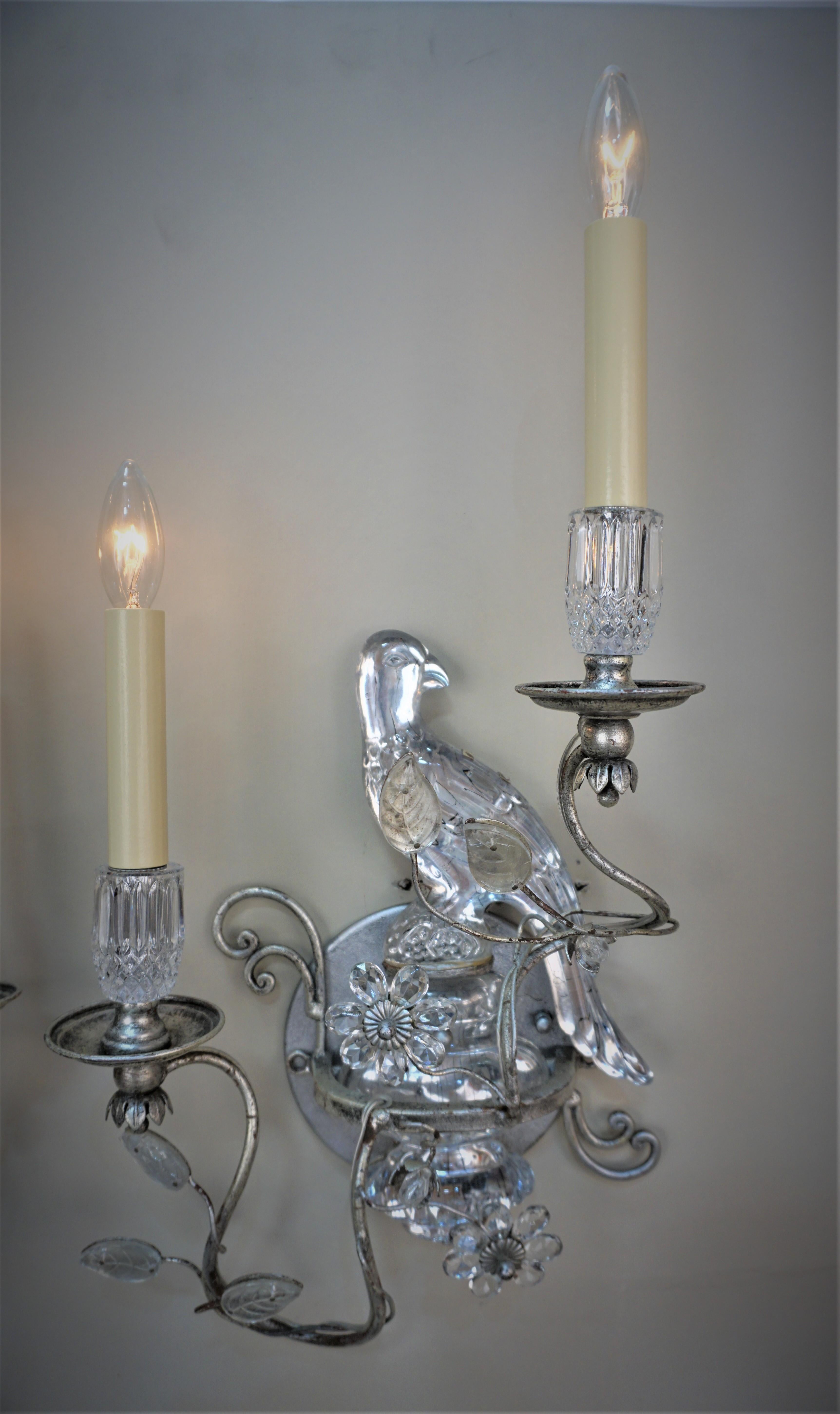 Pair of silver leaf double light wall sconces with parrot design.