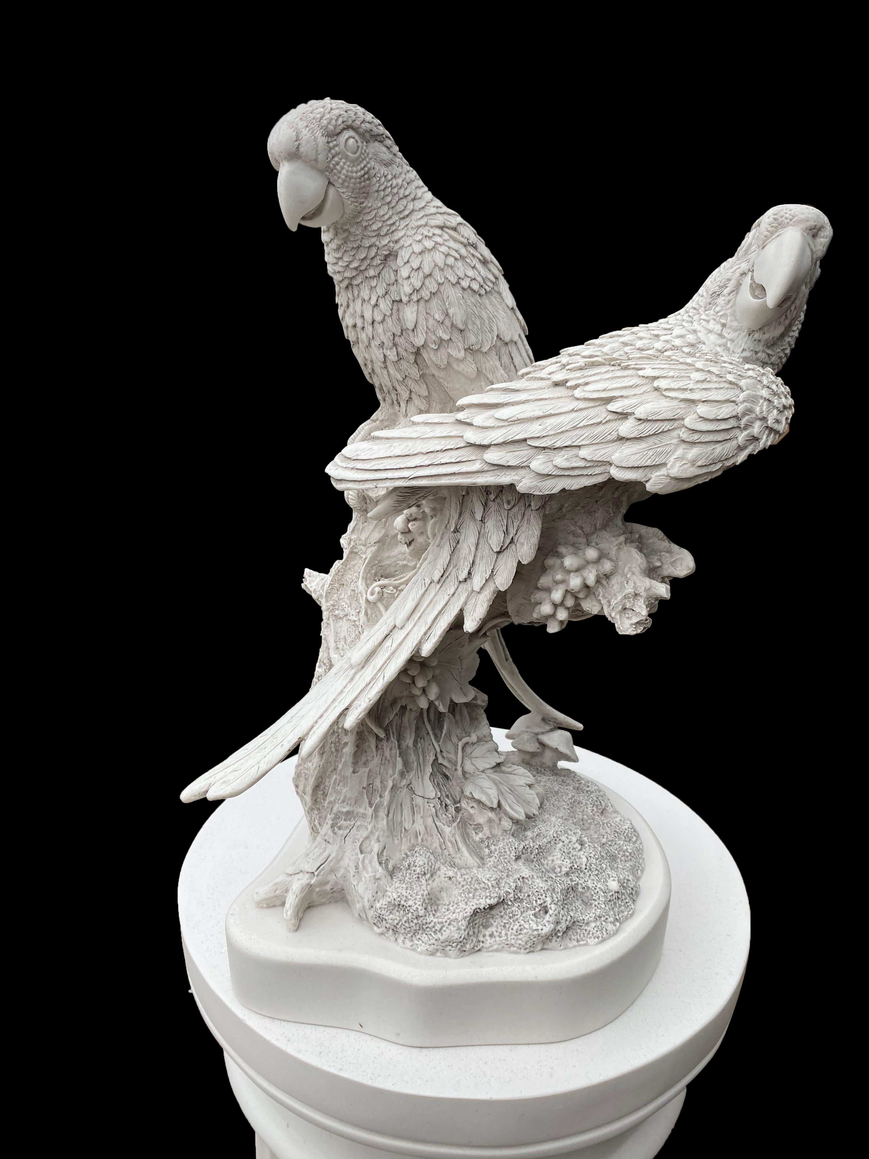 Cette paire captivante de sculptures de perroquets, réalisée au XXe siècle, présente des représentations vibrantes et très détaillées de ces oiseaux exotiques. Chaque perroquet est méticuleusement conçu, présentant une riche palette de couleurs et