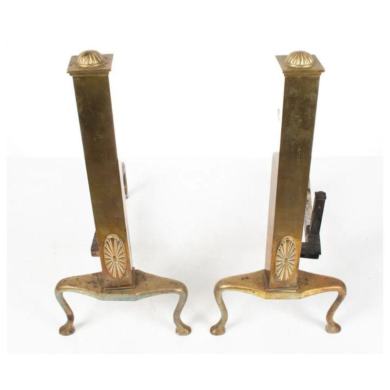 A vintage pair of patera medallion tall brass andirons, a chic and functional addition to any fireplace, exuding elegance and timeless charm. Each andiron features a tall, slender design with a medallion motif and slender cabriole legs, adding a
